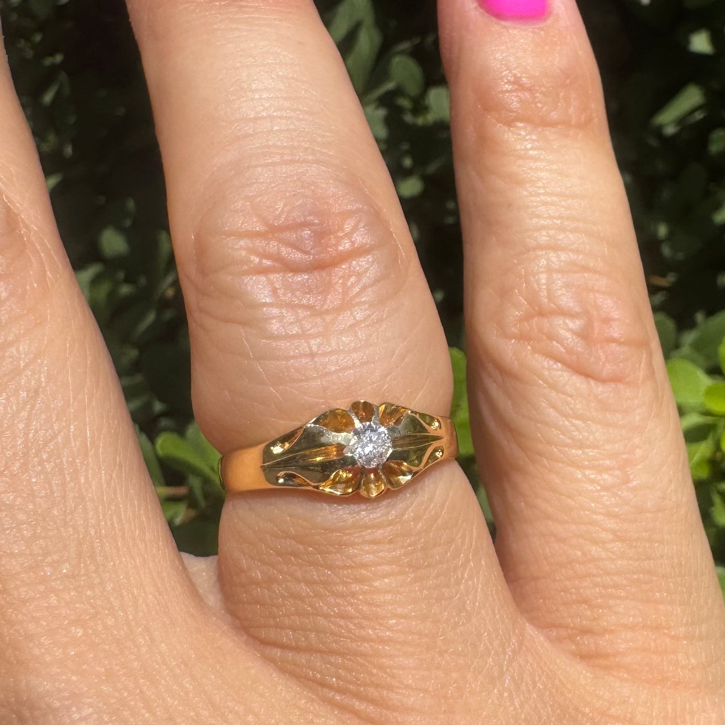 18K gold ring set with a small sparkling diamond at the center.