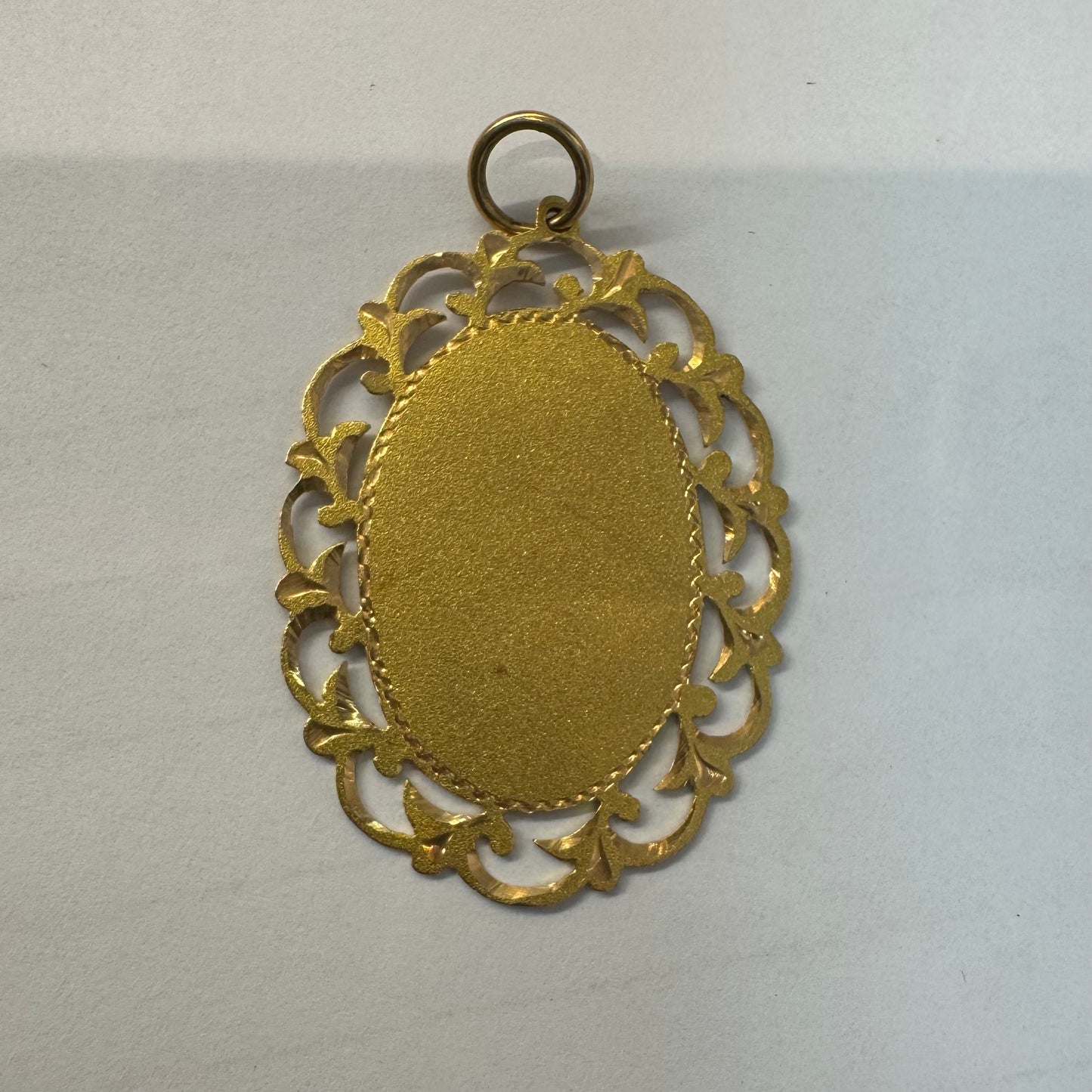 תליון זהב 14 קראט בעיצוב וינטג' יוקרתי, המשלב פלטה מרכזית חלקה עם מסגרת תחרה (Filigree) עדינה ומפורטת.  