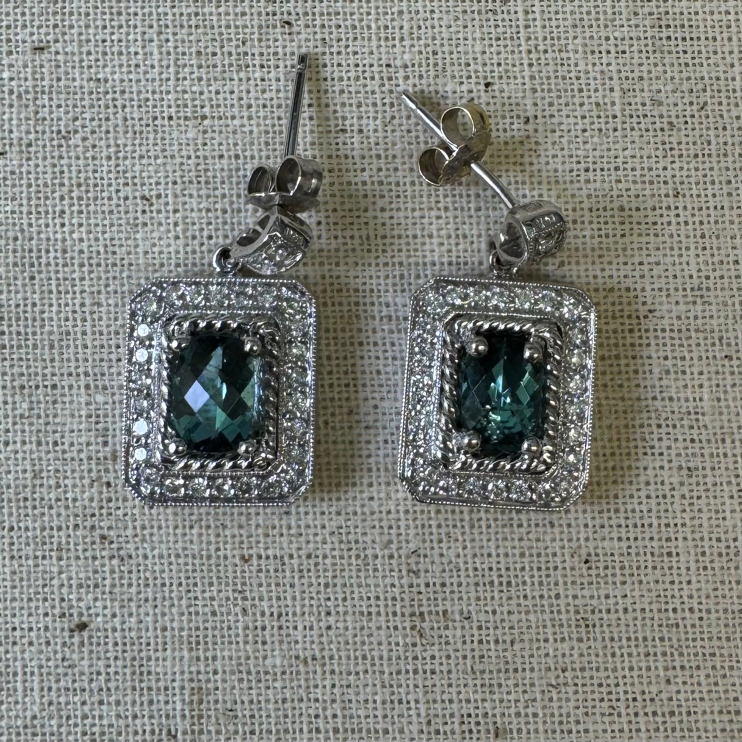 14K gold drop earrings set with emerald-cut Blue Topaz, surrounded by a halo of sparkling Diamonds