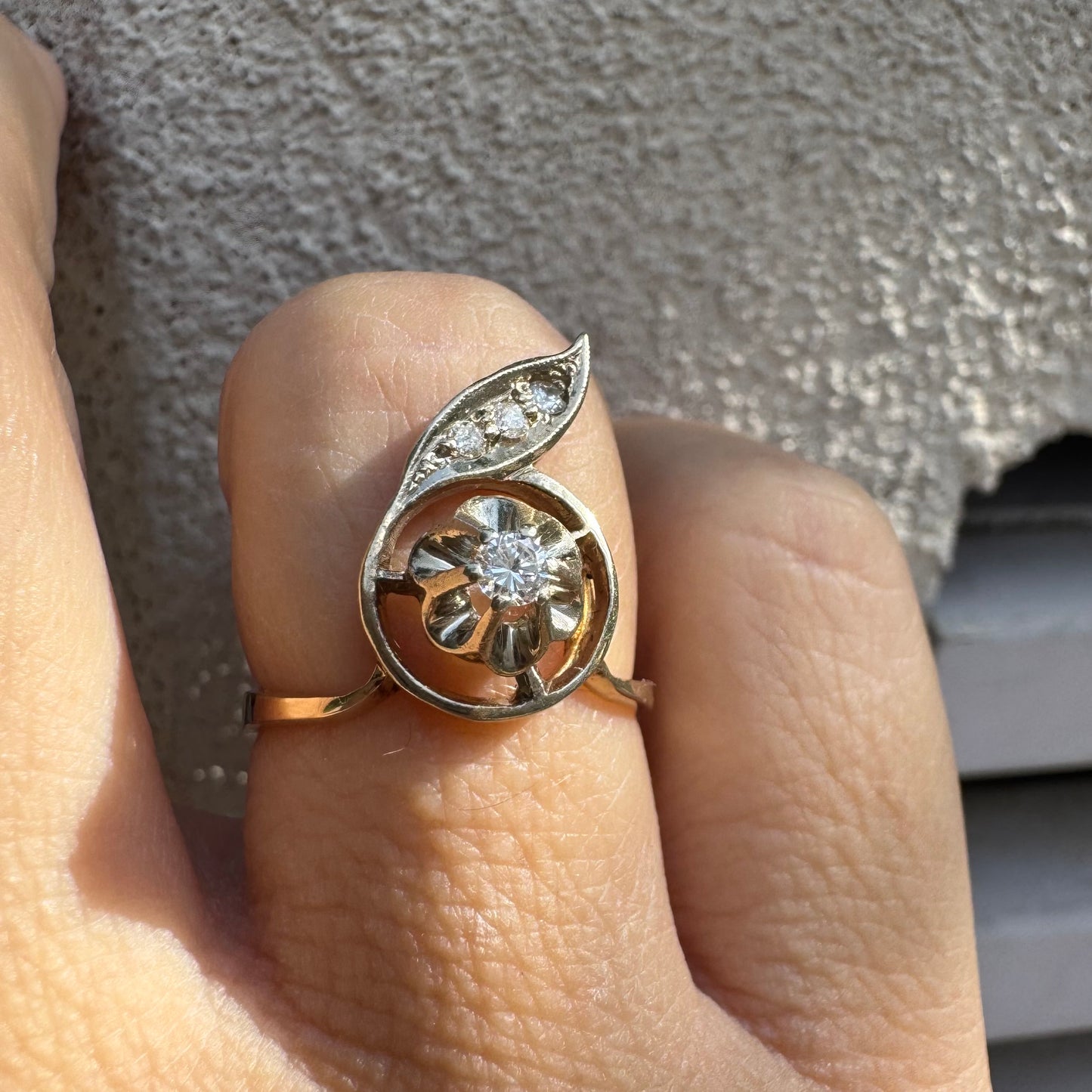 טבעת זהב צהוב 14 קראט בעיצוב פרח עדין המשובצת יהלומים נוצצים .