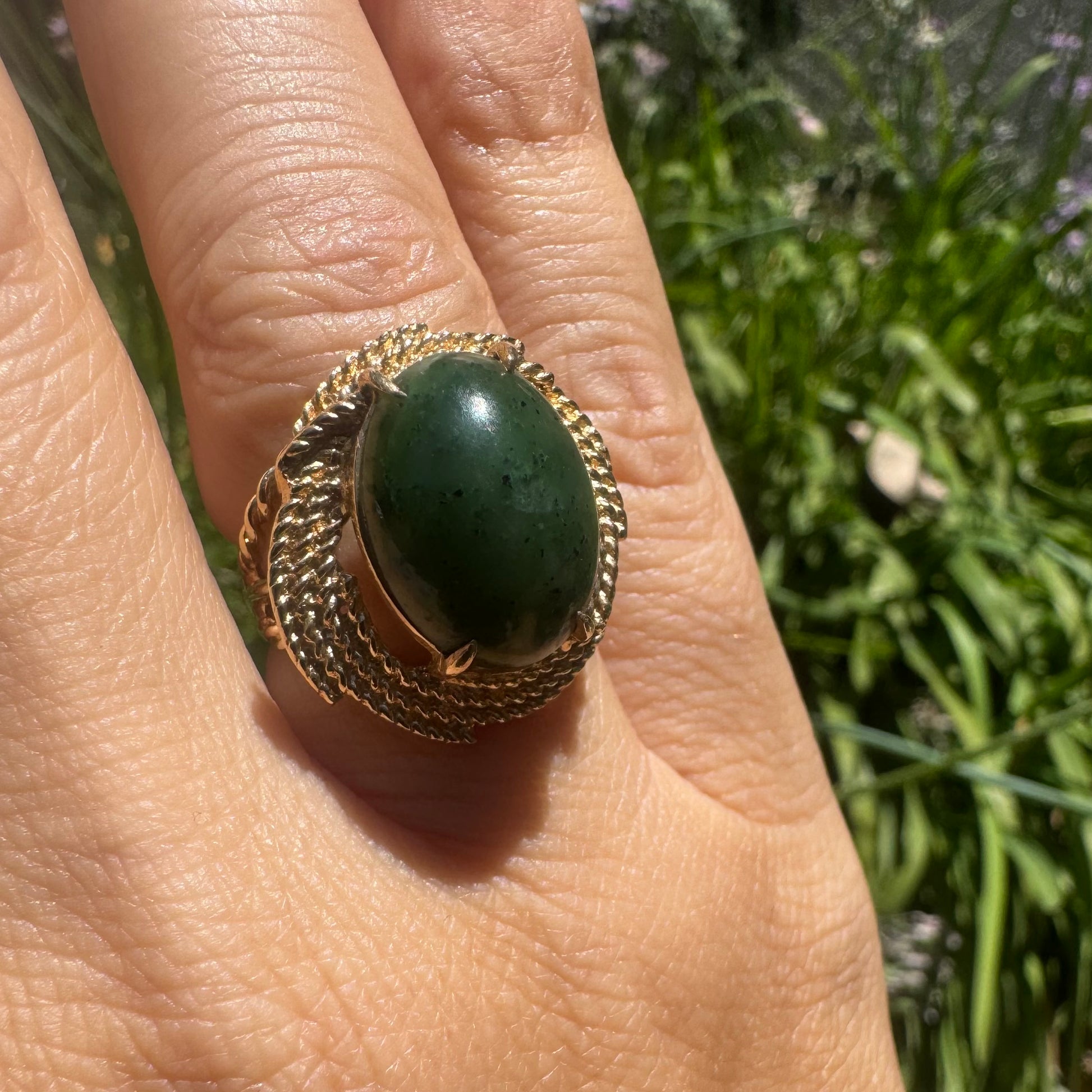 טבעת זהב צהוב 14 קראט משובצת אבן ג׳ייד בצבע ירוקה במסגרת זהב מעוצבת.