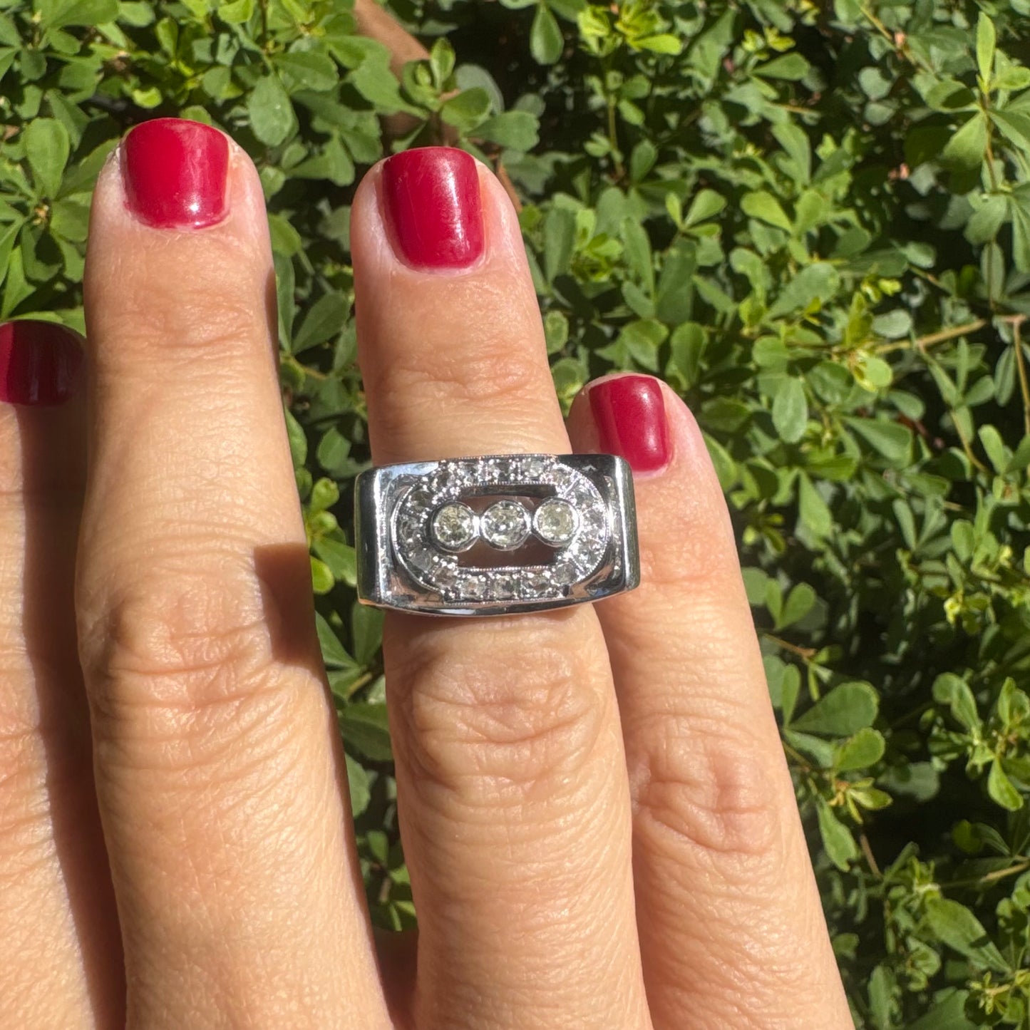 18K gold ring featuring three round 3 Diamonds in the center, framed by a rectangular halo of smaller Diamonds.