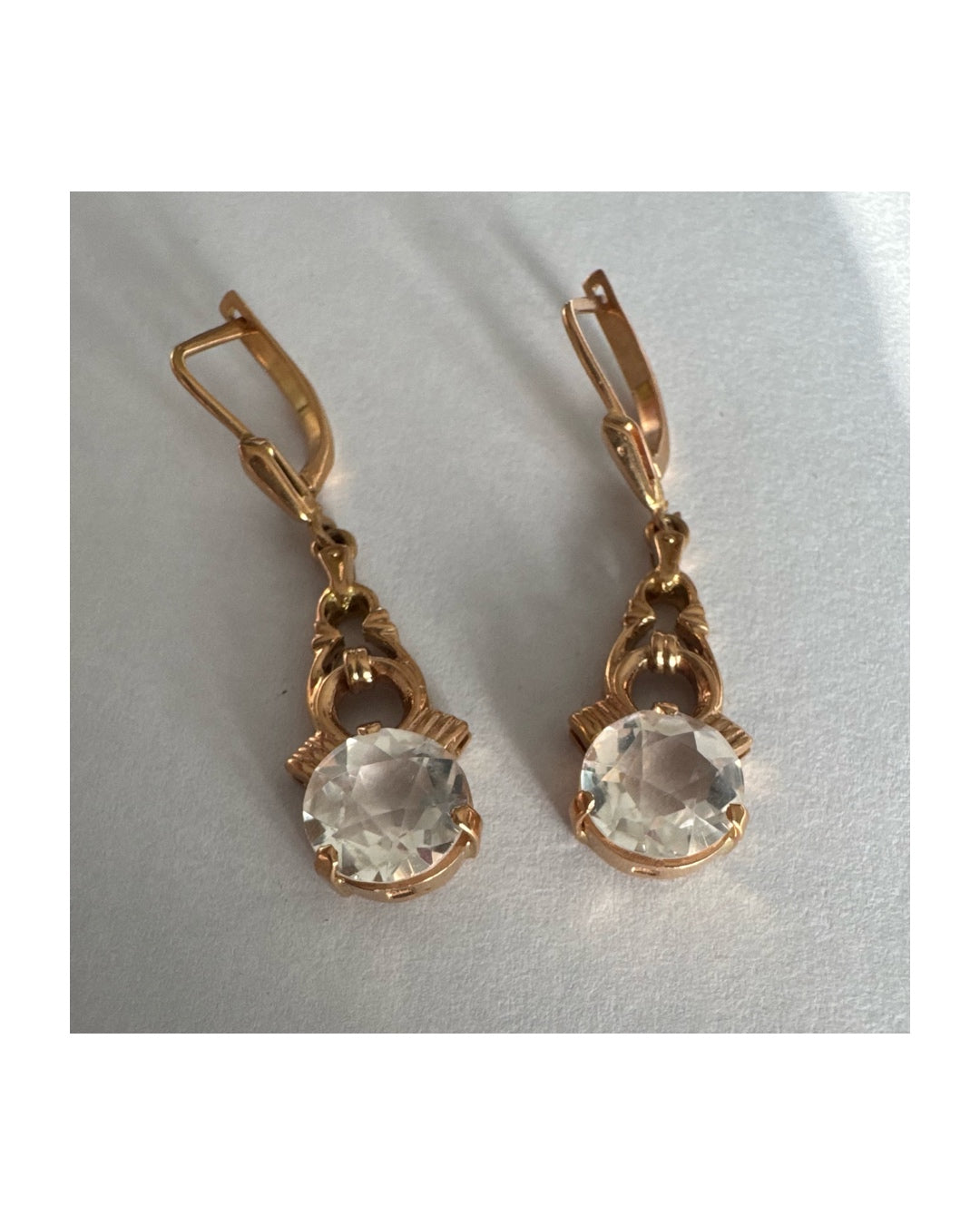 עגילי זהב 14 קראט, תלויים, בעיצוב עדין ונוסטלגי, משובצים באבני חן חתוכות שקופות בסגנון עתיק.