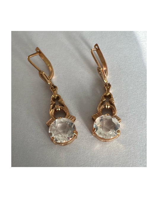 עגילי זהב 14 קראט, תלויים, בעיצוב עדין ונוסטלגי, משובצים באבני חן חתוכות שקופות בסגנון עתיק.