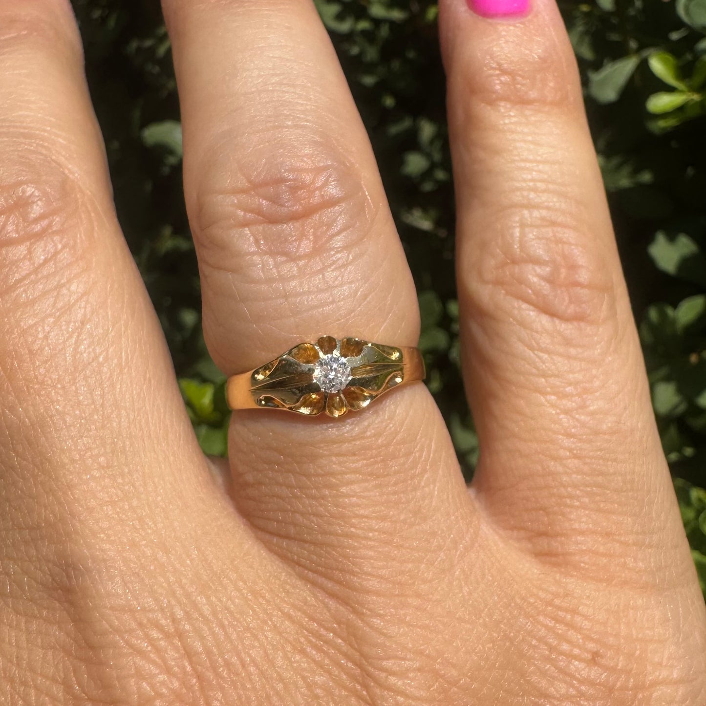 18K gold ring set with a small sparkling diamond at the center.
