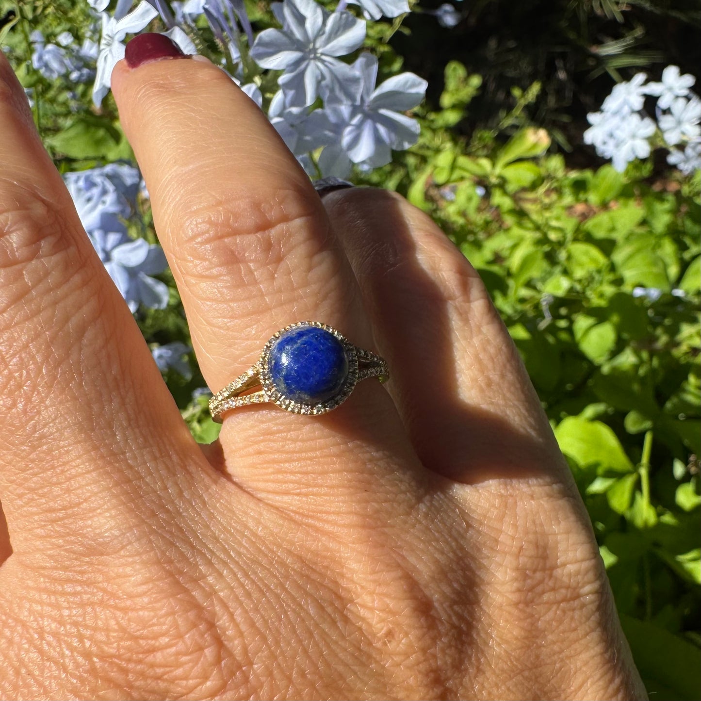 14K gold ring set with a round Lapis Lazuli gemstone, surrounded by a delicate halo of sparkling Diamonds.