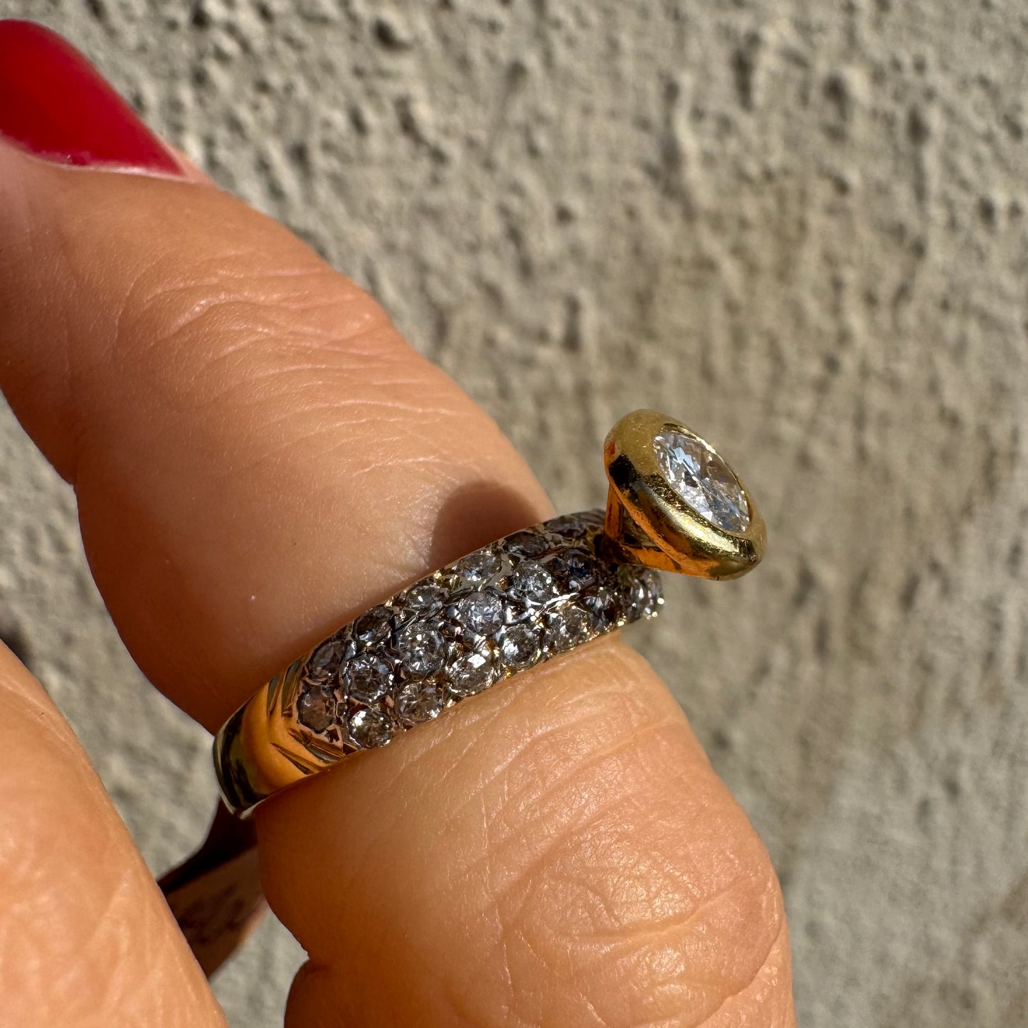 טבעת זהב צהוב 14 קראט משובצת יהלום עגול ויהלומים נוספים על הרצועה.