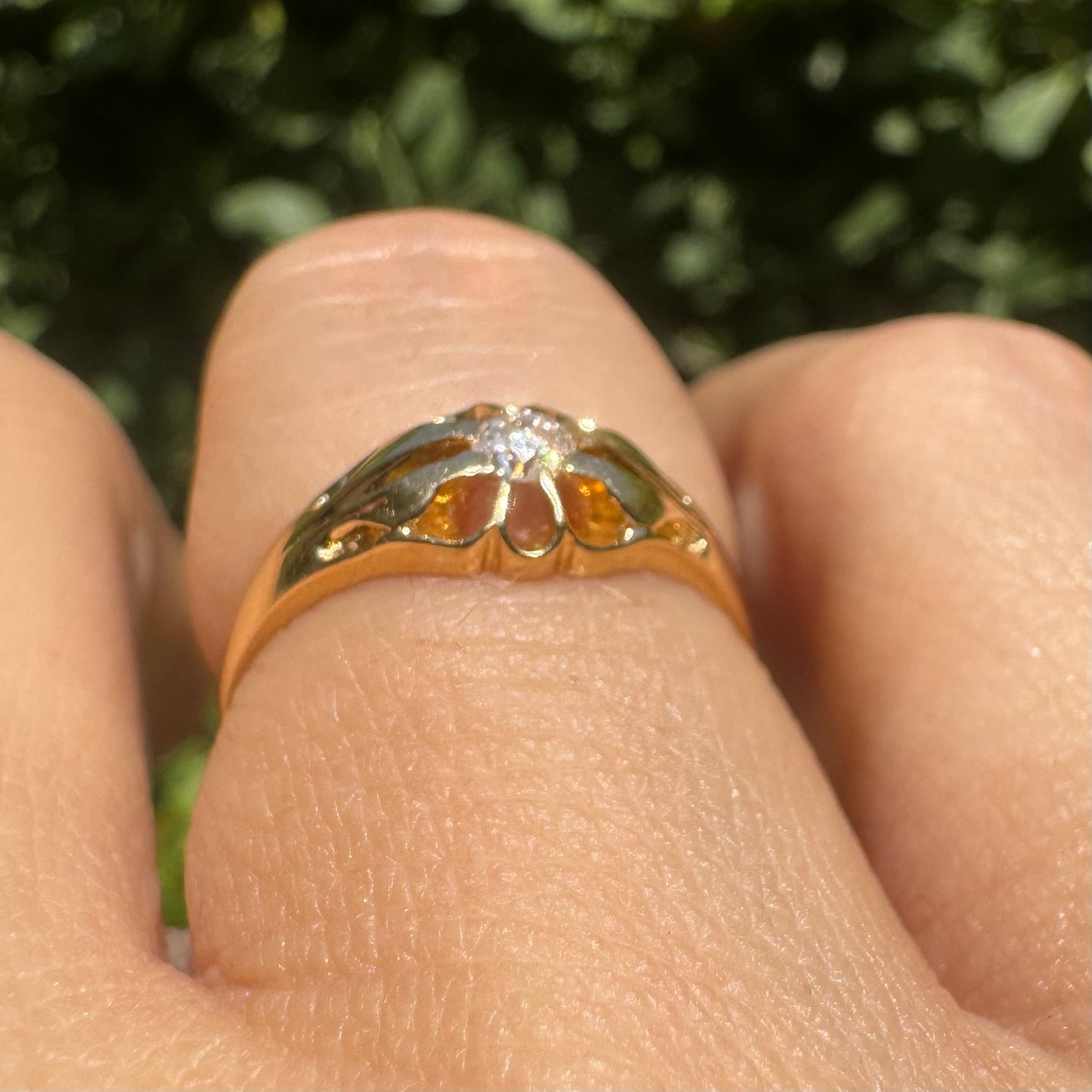 18K gold ring set with a small sparkling diamond at the center.