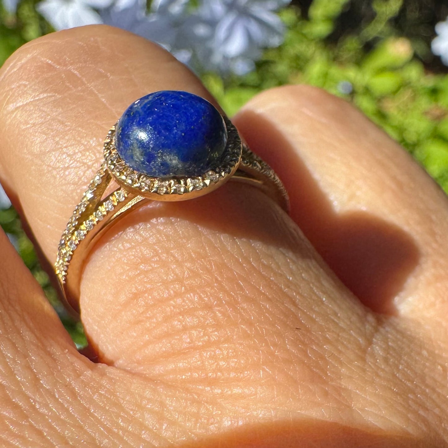 14K gold ring set with a round Lapis Lazuli gemstone, surrounded by a delicate halo of sparkling Diamonds.