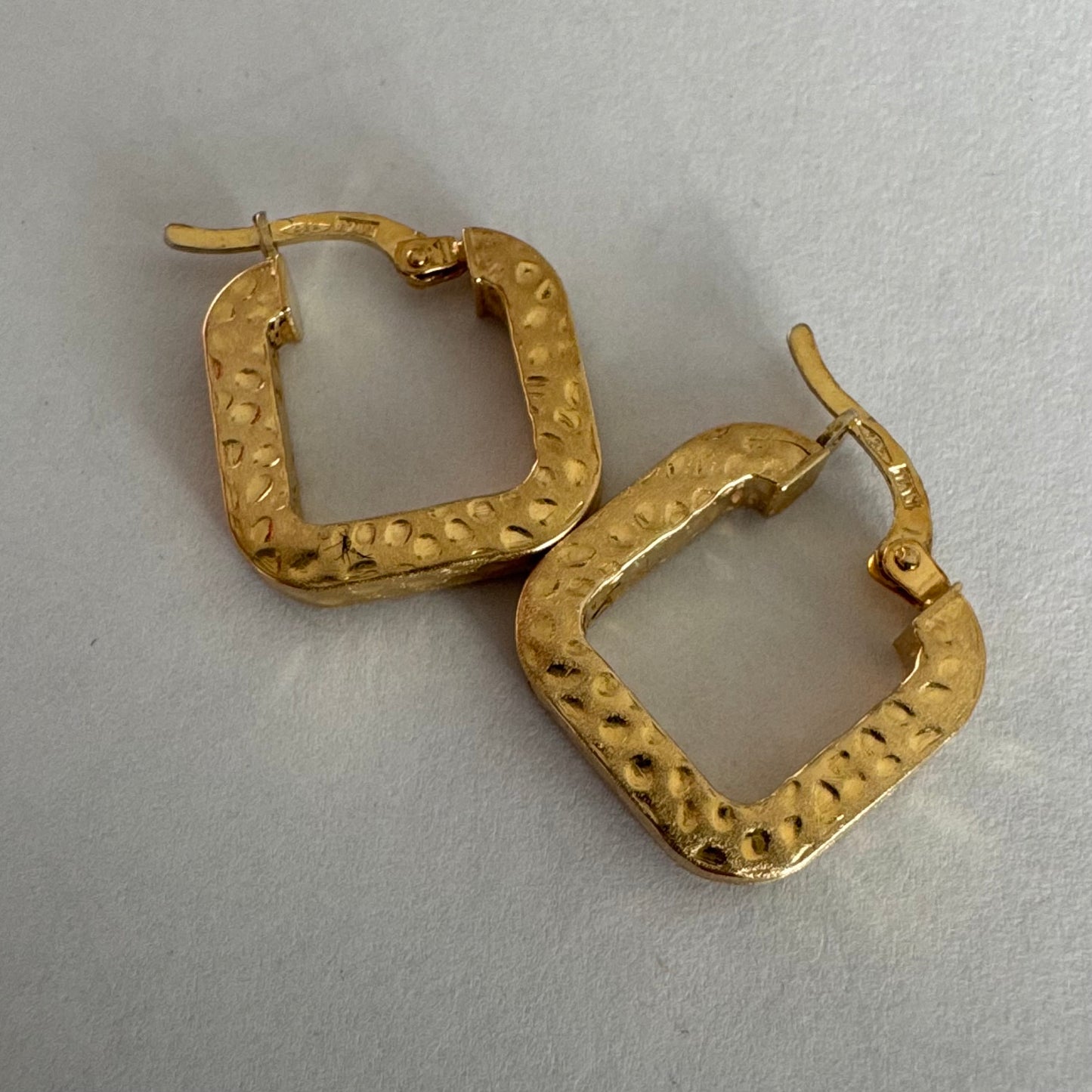 עגילי חישוק מרובעים מזהב 14 קראט בגימור מחוספס ומטאלי. 