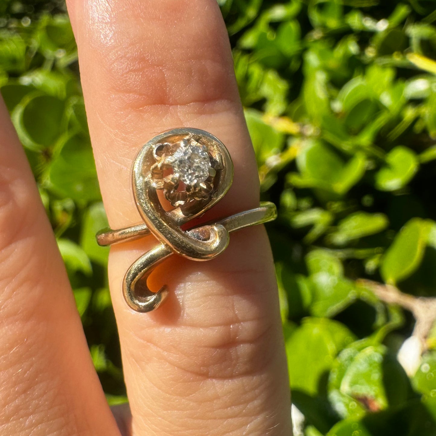 14K gold ring set with a brilliant-cut Diamond, embraced by a flowing, sculptural gold design