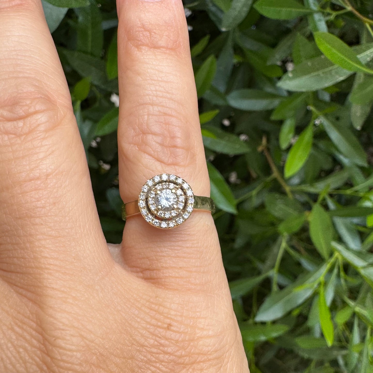 14K gold ring with a round center Diamond, surrounded by two rows of small sparkling Diamonds.