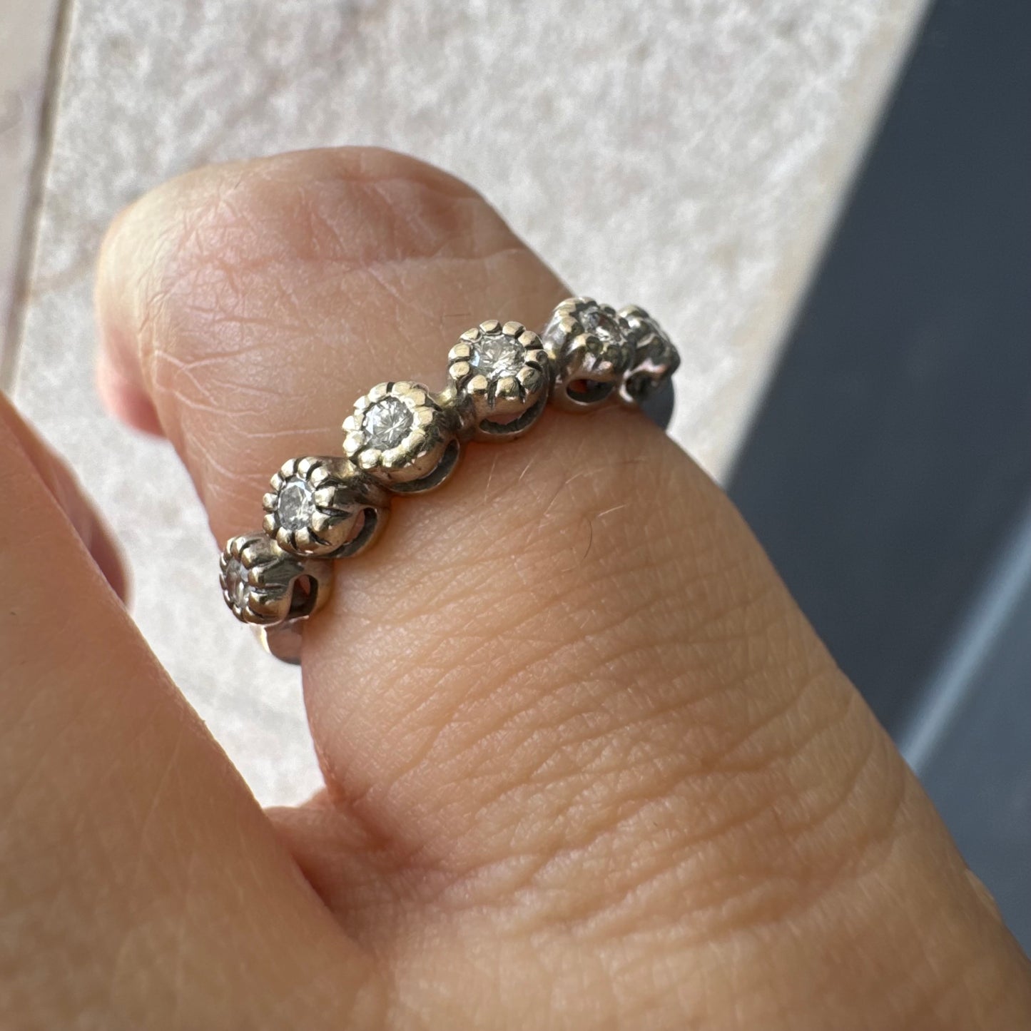 טבעת זהב 14 קראט בסגנון “חצי איטרניטי”, משובצת יהלומים עגולים בחיתוך עגול במסגרת עדינה בהשראת פרחים.