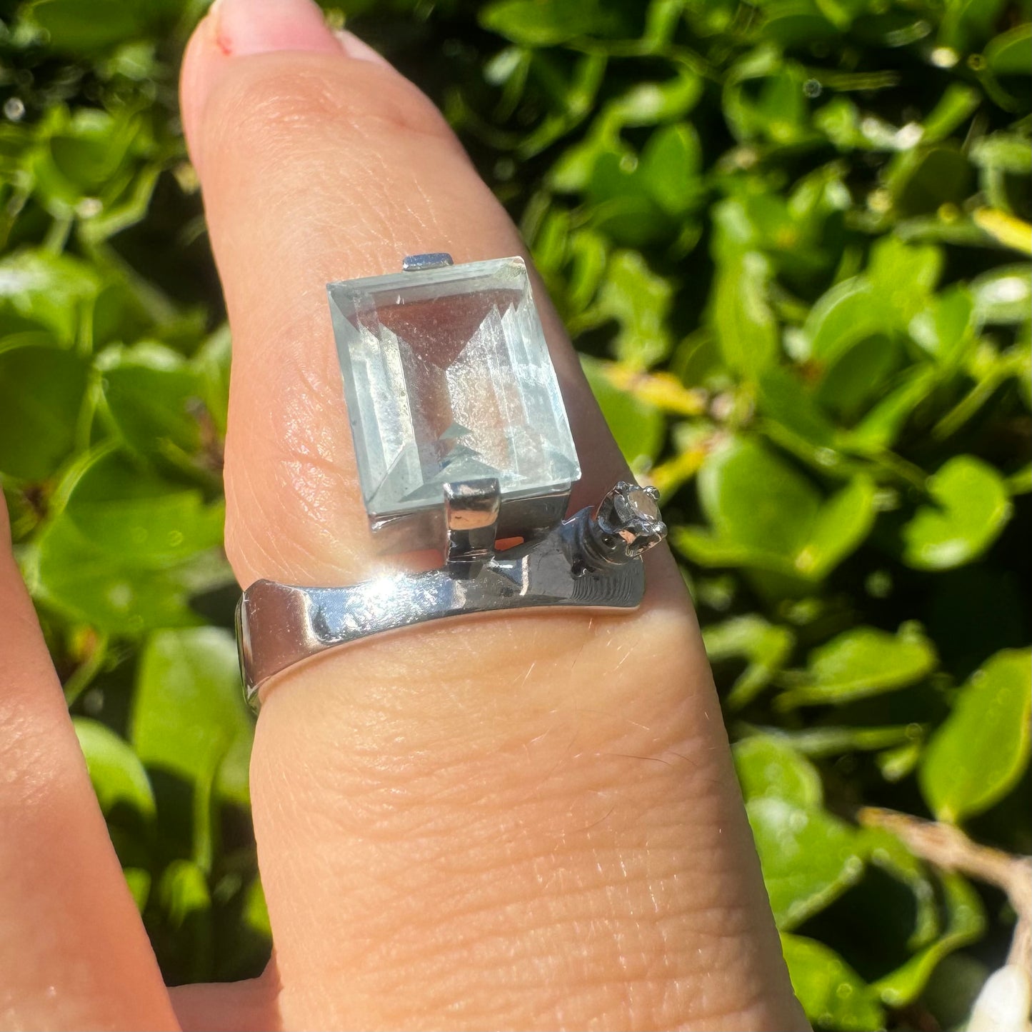 18K gold ring set with a rectangular step-cut Aquamarine set in a sculptural white gold band & a sparkling Diamond
