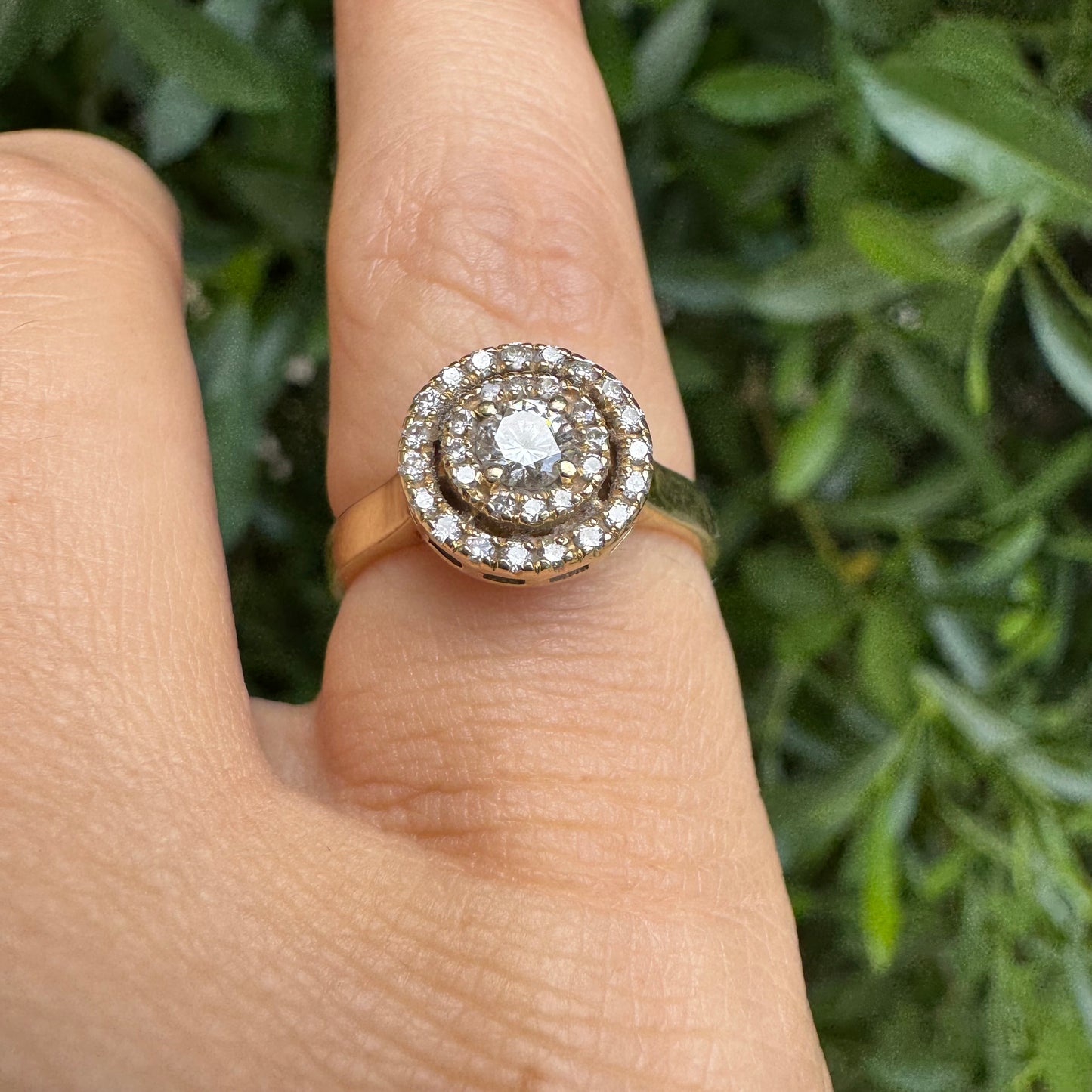 14K gold ring with a round center Diamond, surrounded by two rows of small sparkling Diamonds.