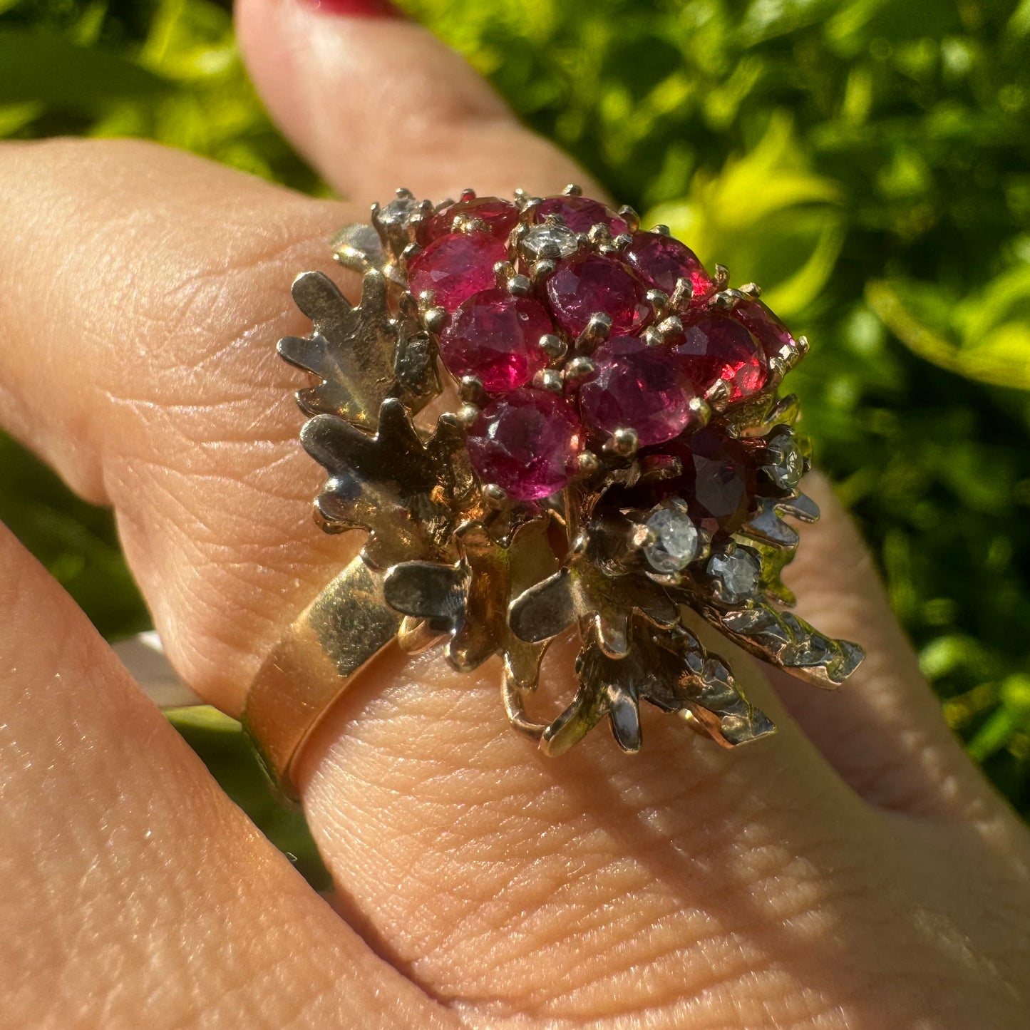 14K gold ring set with a vibrant cluster of deep red rubies and sparkling diamonds.