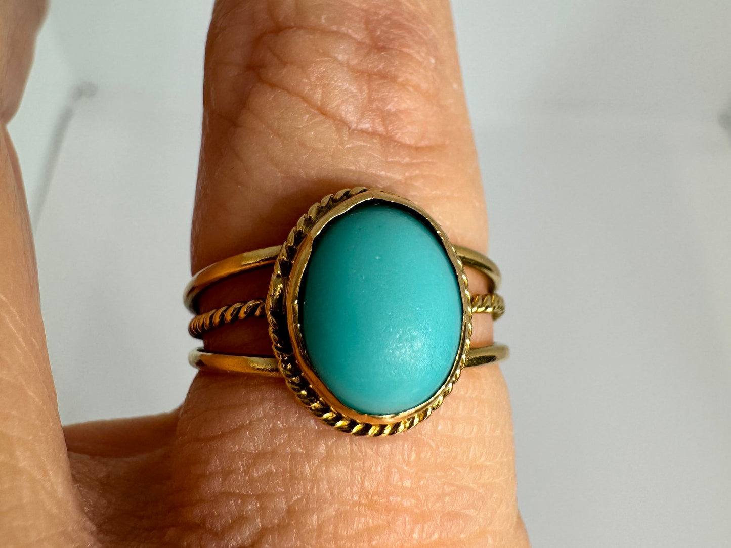 14K gold ring set with an oval Turquoise stone in a delicate rope-style bezel