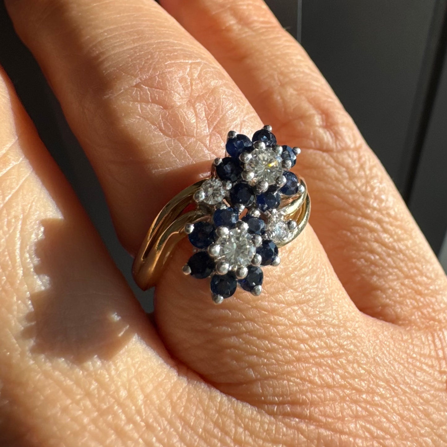 טבעת זהב צהוב 14 קראט משובצת אבני ספיר ויהלומים בעיצוב פרחים כפול.