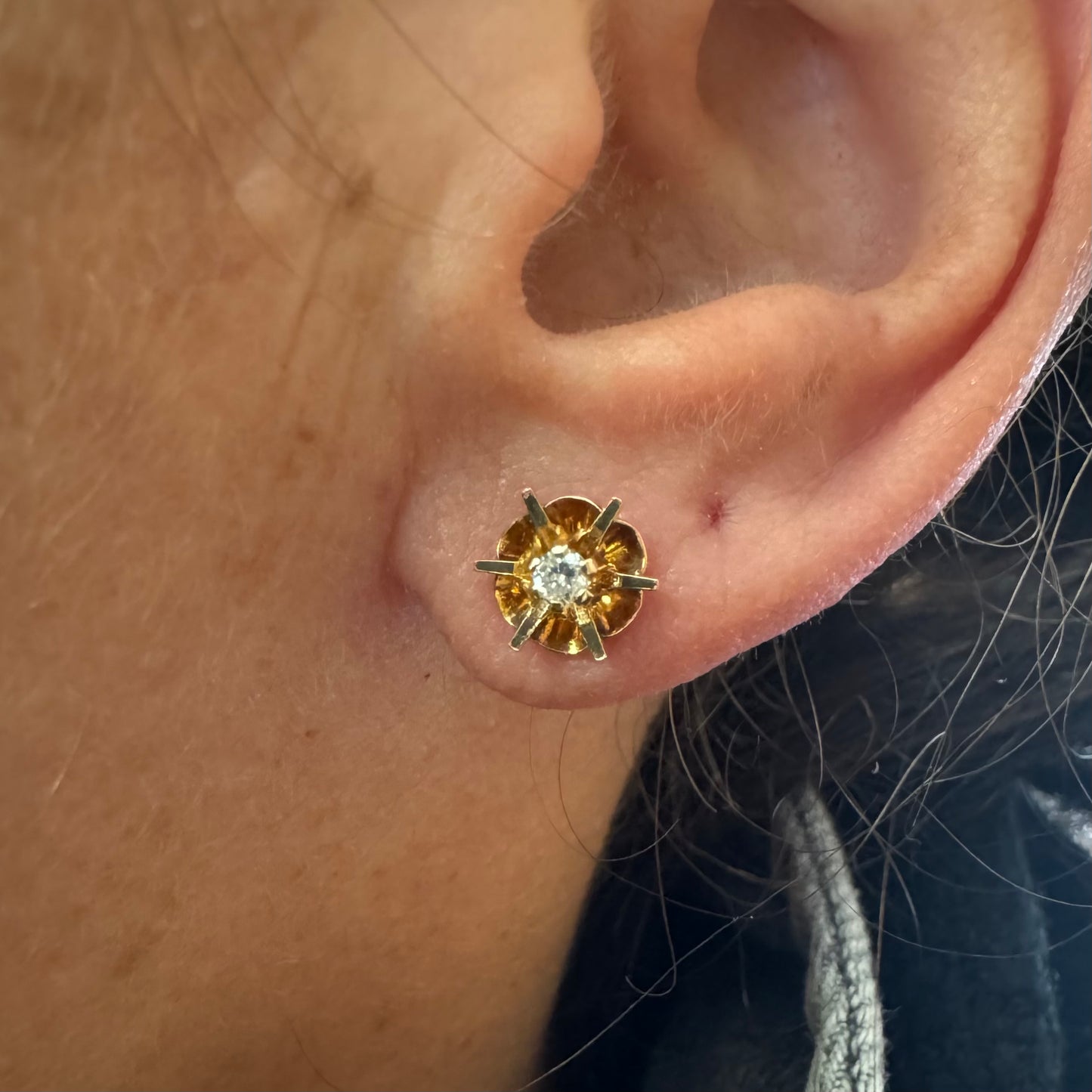 עגיל צמוד זהב צהוב 14 קראט בעיצוב פרח עדין, עם יהלום לבן במרכזו.