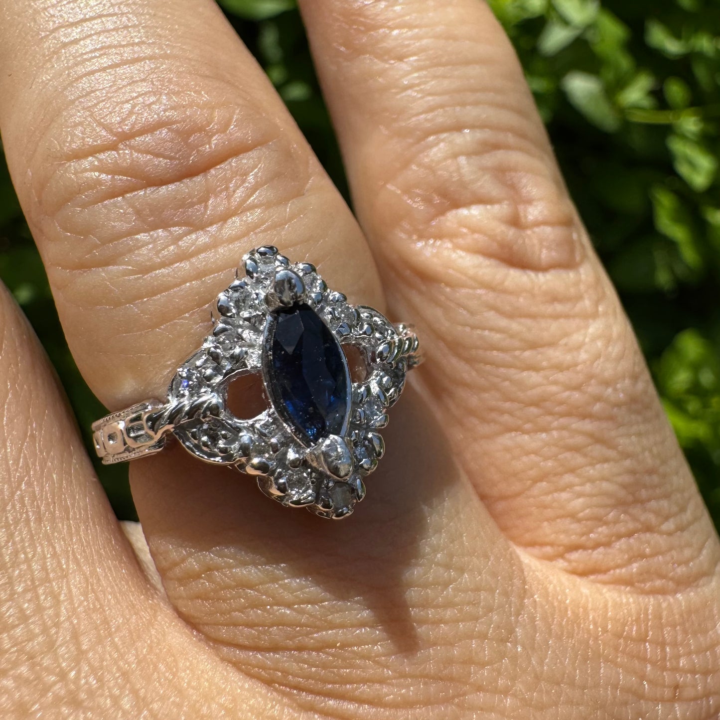 14K gold ring set with a marquise-cut Sapphire at its center, framed by an intricate halo of sparkling Diamonds