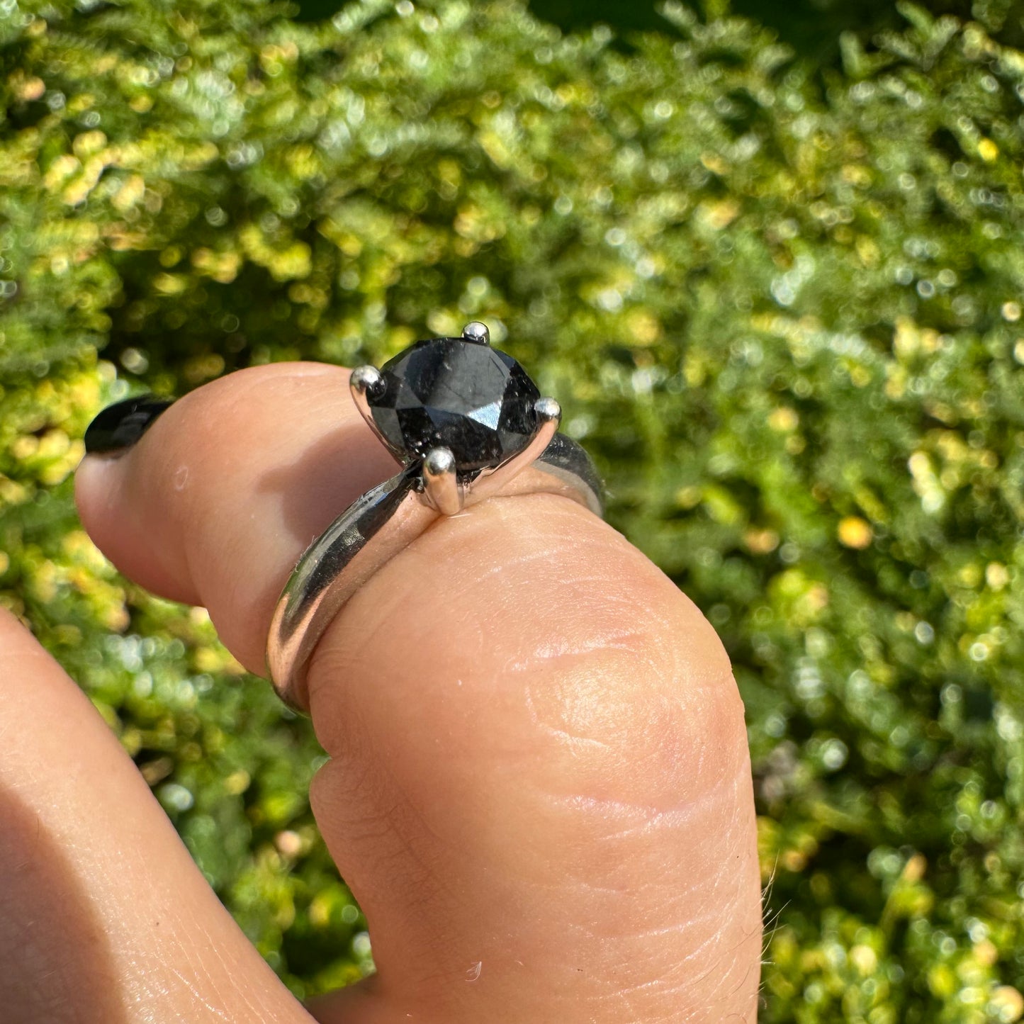 טבעת סוליטר זהב לבן 10 קראט אלגנטית ובעלת נוכחות, משובצת ביהלום שחור בחיתוך עגול במסגרת קלאסית בעלת ארבע שיניים מזהב לבן.