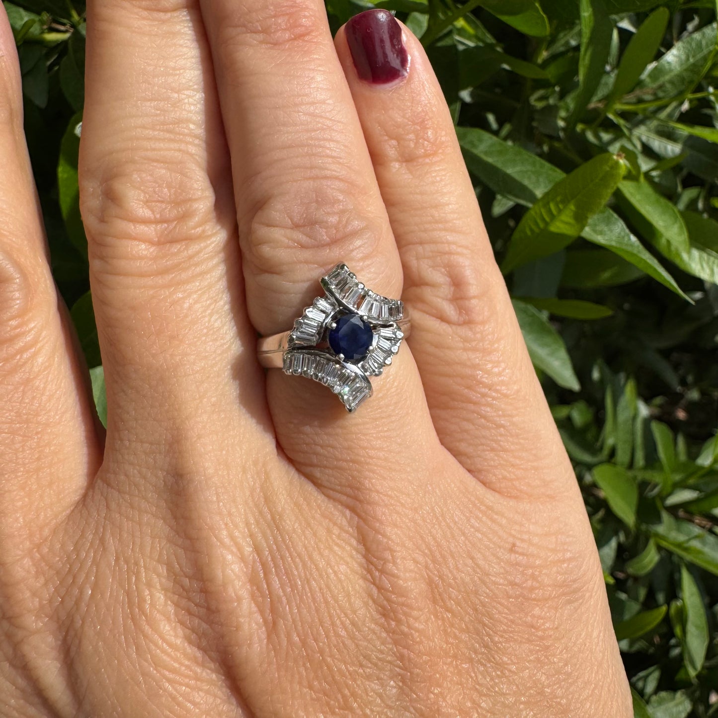 14K gold ring set with a round deep blue sapphire at the center, surrounded by baguette cut Diamonds