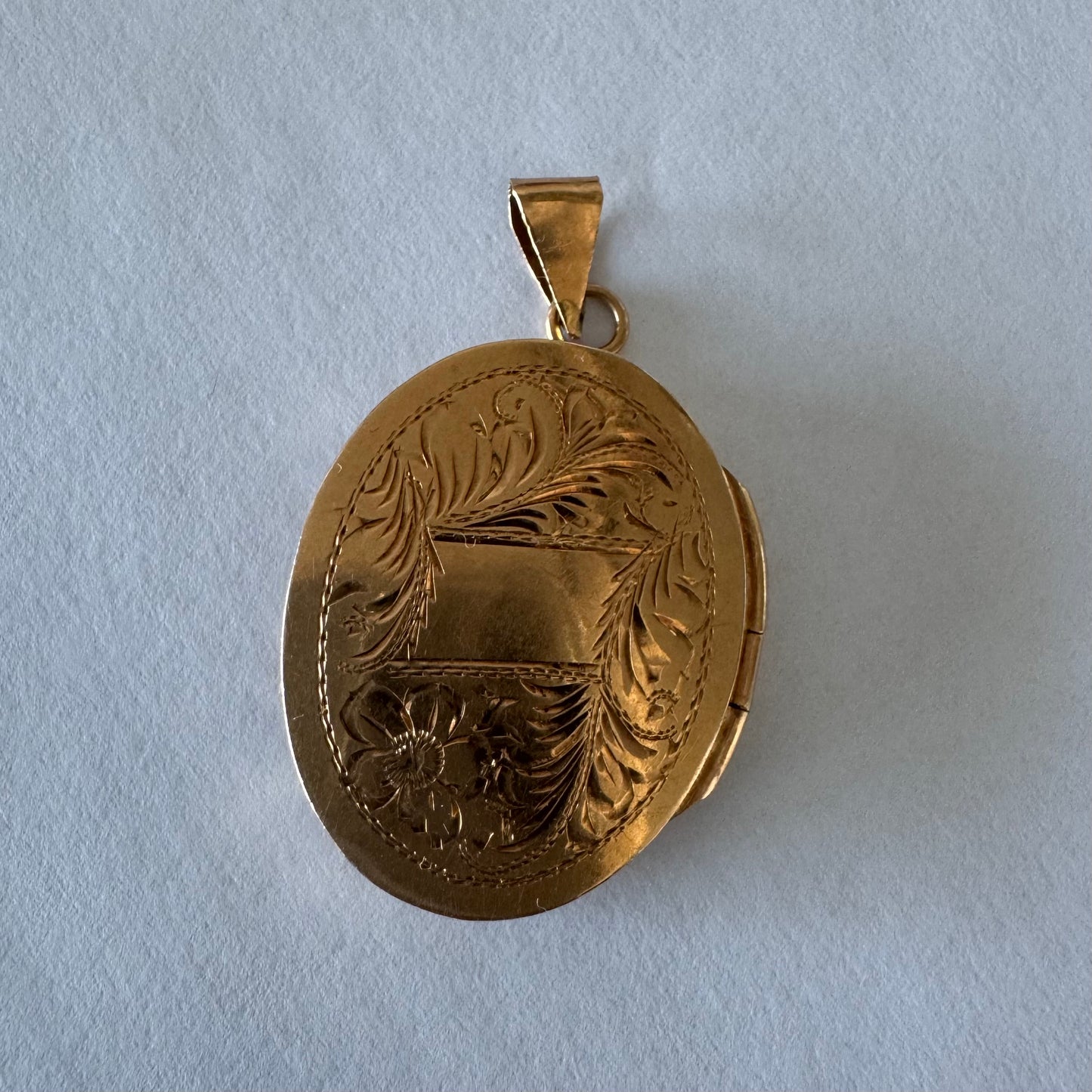 תליון לוקט זהב 14 קראט אובלי עם עיטור חריטה פרחית עדינה בעבודת יד ומסגרת אלגנטית ופתיחה לשמירת זיכרון קטן ויקר ללב.