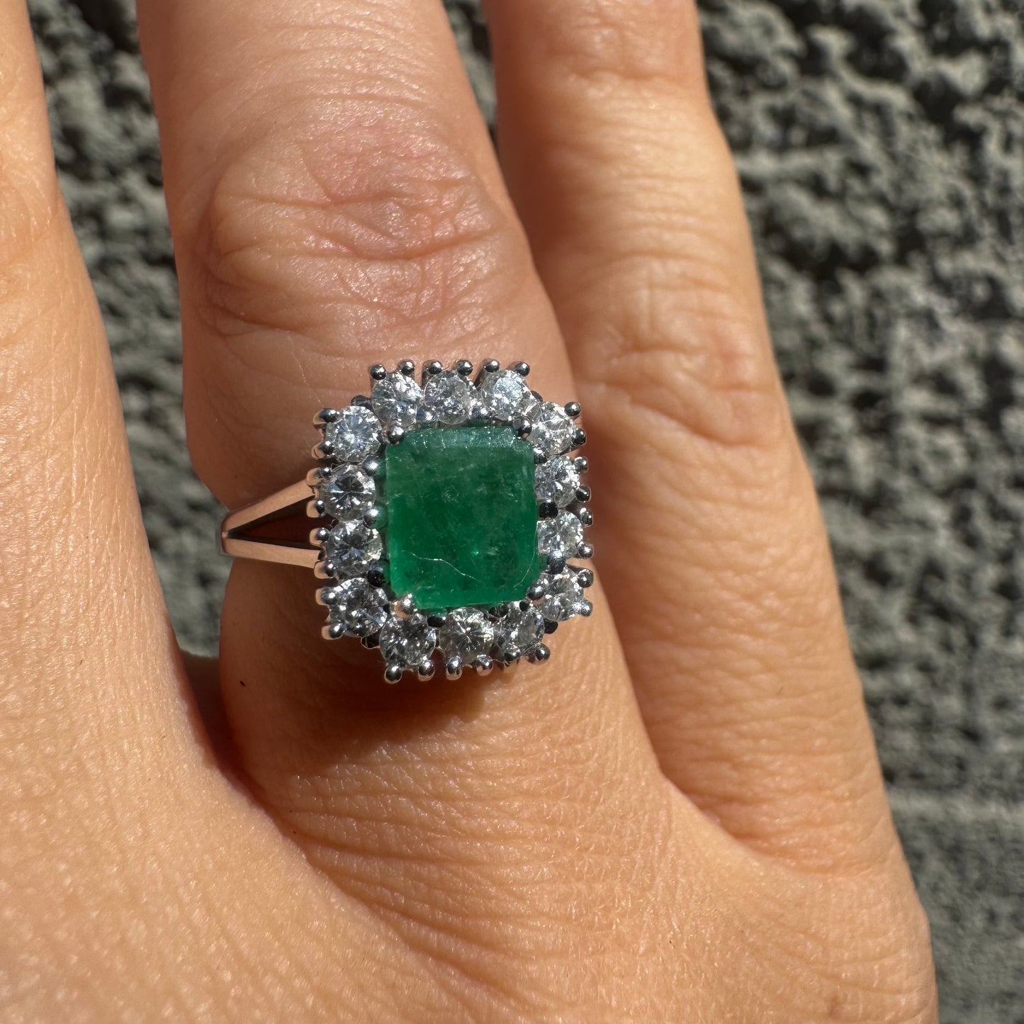 טבעת זהב לבן 18 קראט משובצת אבן אמרלד במרכז וסביבה משובצים יהלומים 