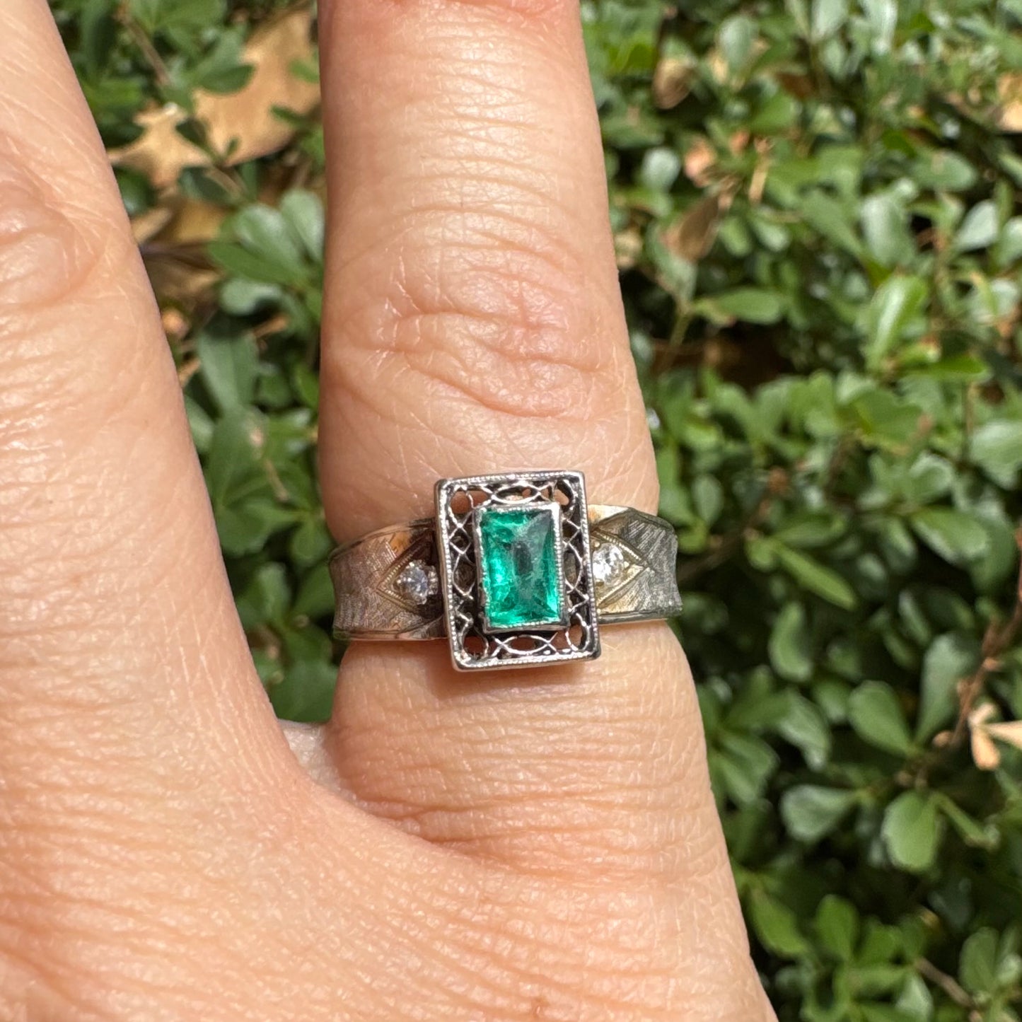 14K gold ring set with a vibrant emerald-cut Emerald at its center, framed by delicate filigree work
