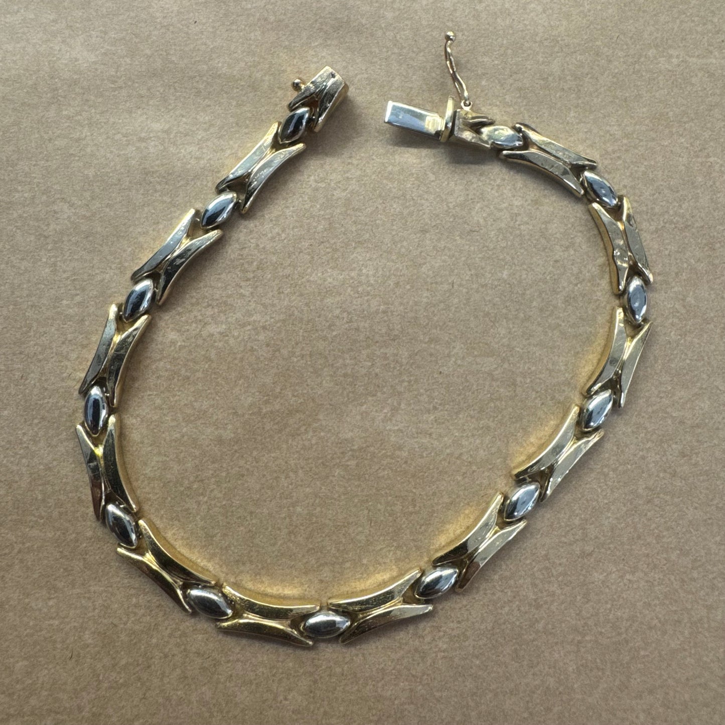 צמיד זהב צהוב וזהב לבן 14 קראט בעיצוב גאומטרי מיוחד, עם חיבורים בצורת X מזהב צהוב ושיבוצים מבריקים בזהב לבן