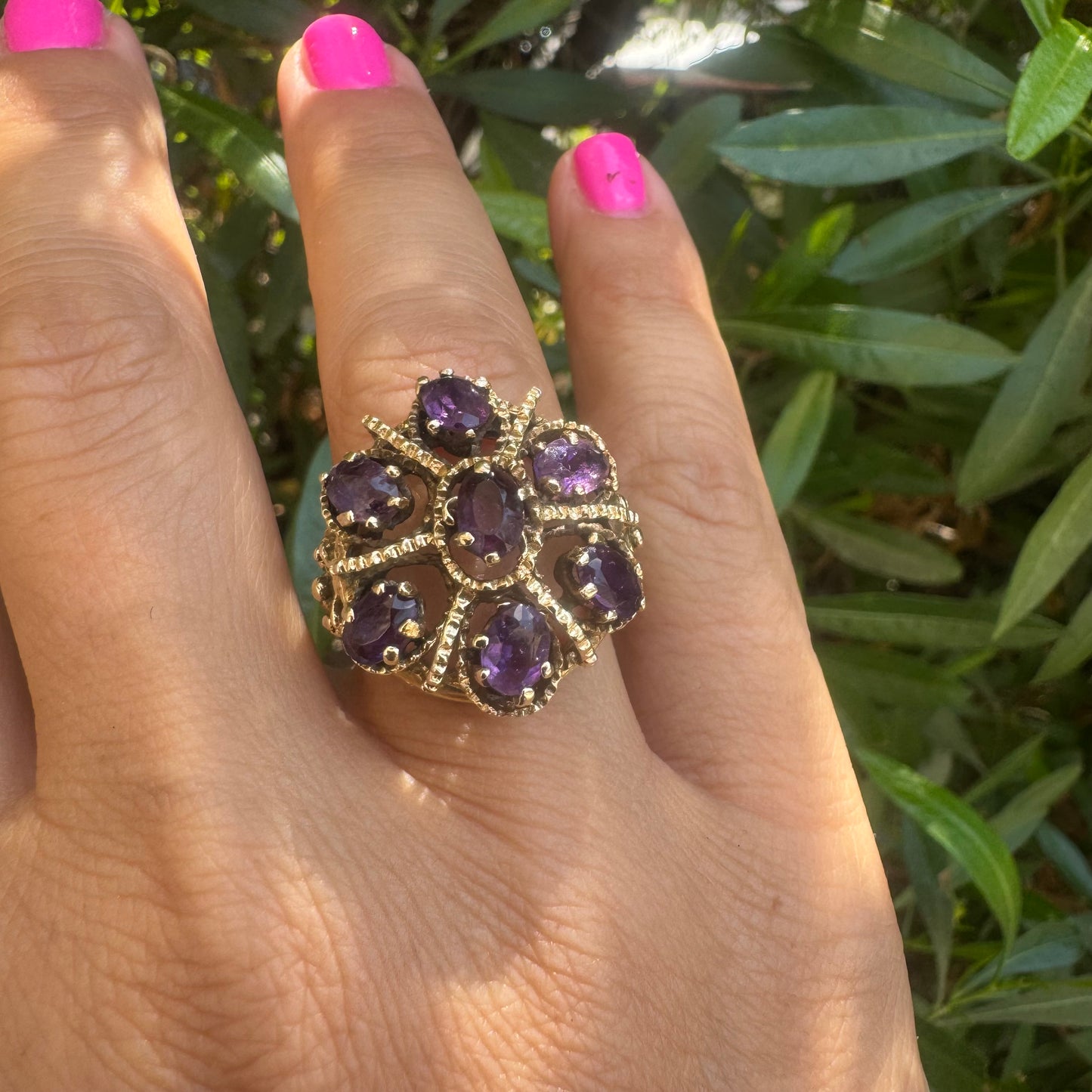 14K gold ring set with deep purple amethysts in an ornate floral design.