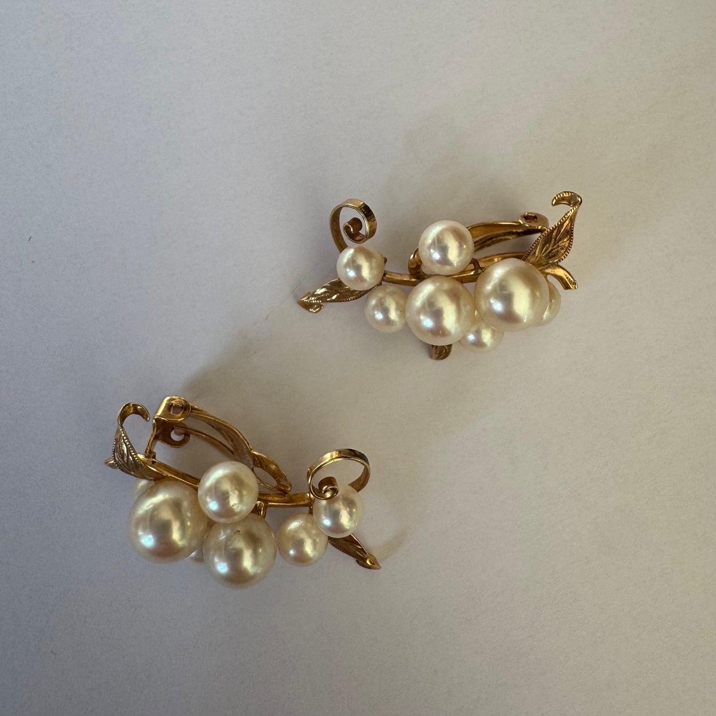 עגילי קליפס זהב 14 קראט, משובצים אשכול פנינים בגווני לבן-קרם.