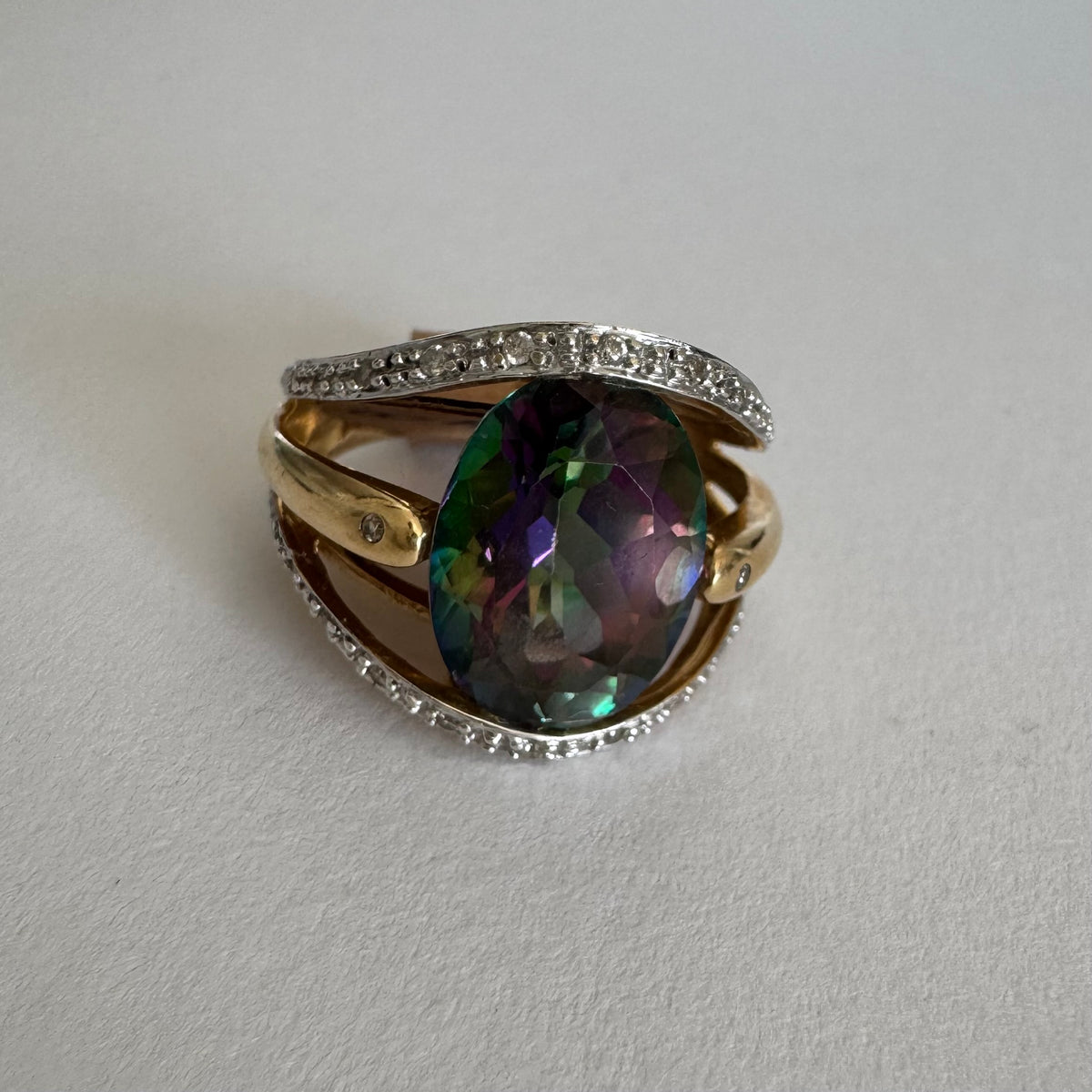 14K gold ring set with an oval Mystic Topaz