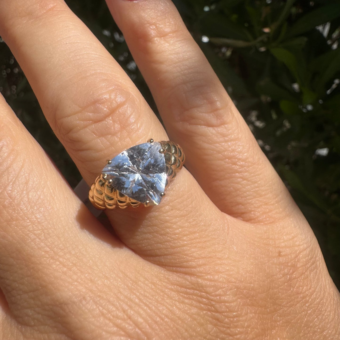 10K gold ring featuring a large, triangular-cut transparent gemstone set in a bold textured band