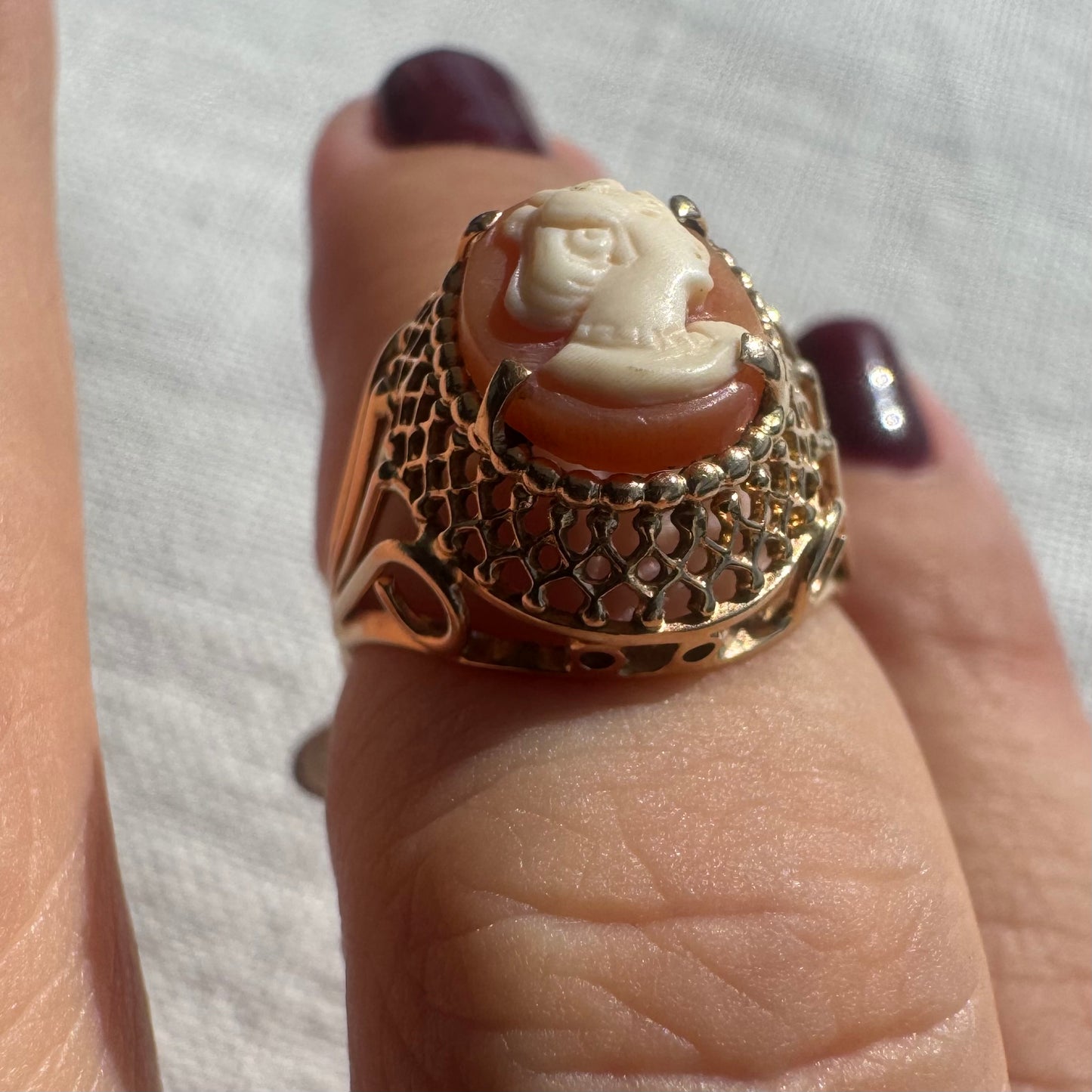 18K gold ring featuring a hand-carved Cameo of a delicate female profile in ivory tones on a warm Coral background.