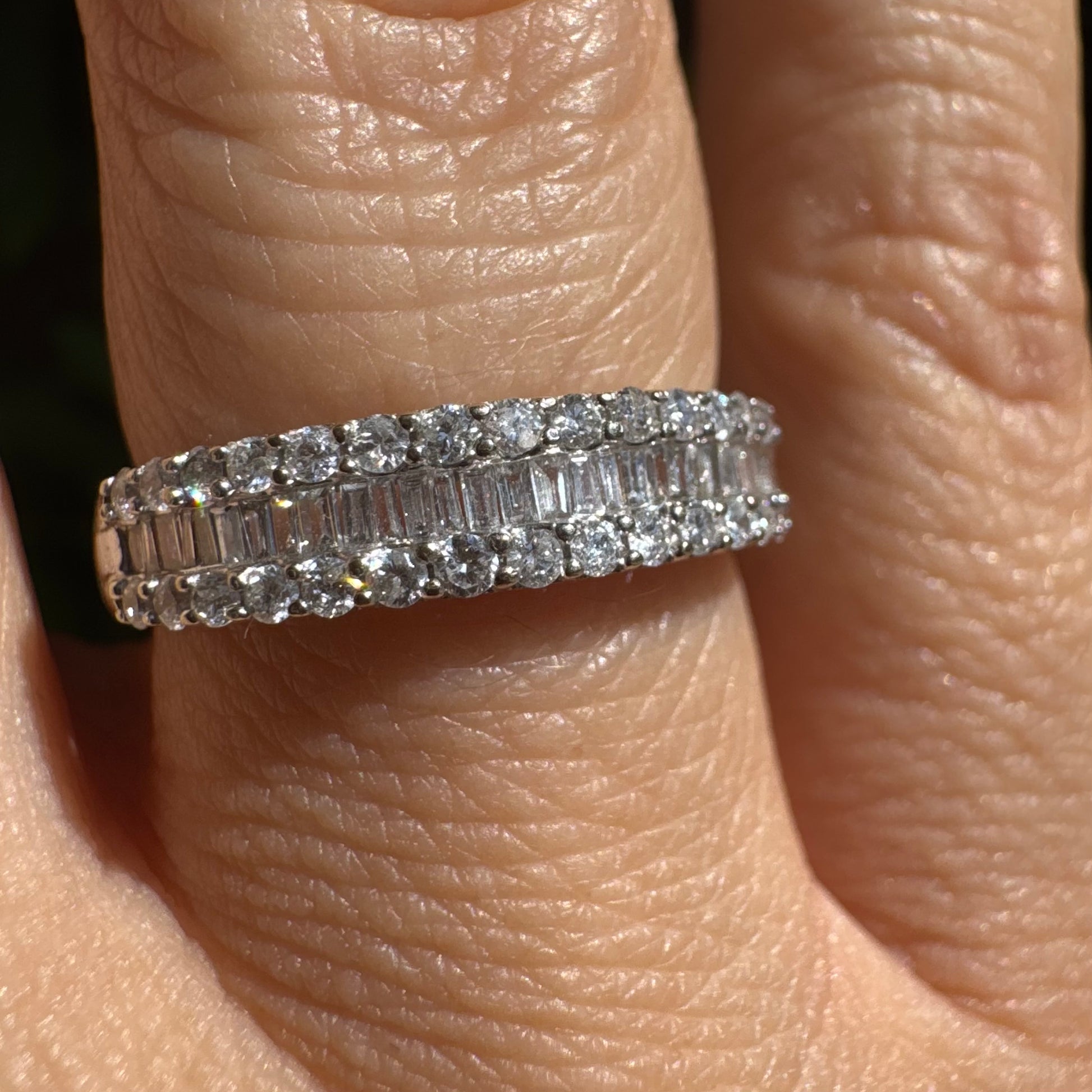 טבעת זהב לבן 14 קראט משובצת בשני סוגי חיתוכי יהלומים – שורת יהלומים עגולים משני הצדדים ובמרכז שורת יהלומים בחיתוך באגט (baguette cut).