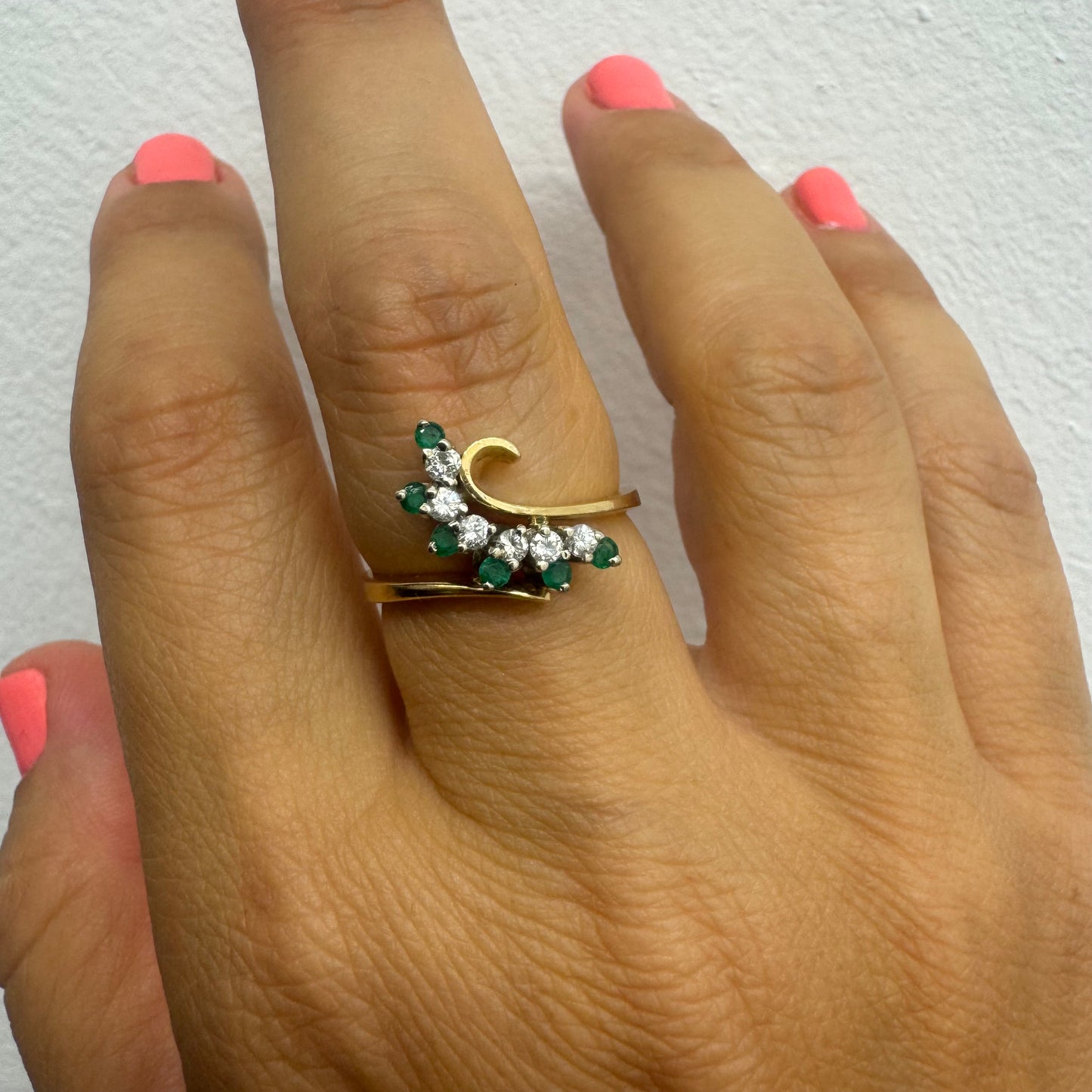 14K gold open ring featuring a delicate swirl set with Emeralds and brilliant-cut Diamonds
