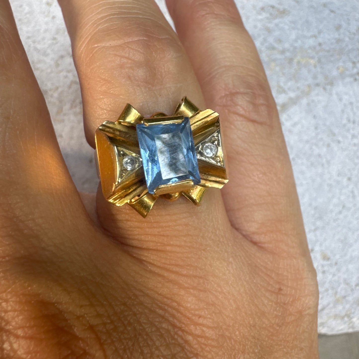 18K gold bow ring, set with a rectangular Blue Topaz gemstone at the center