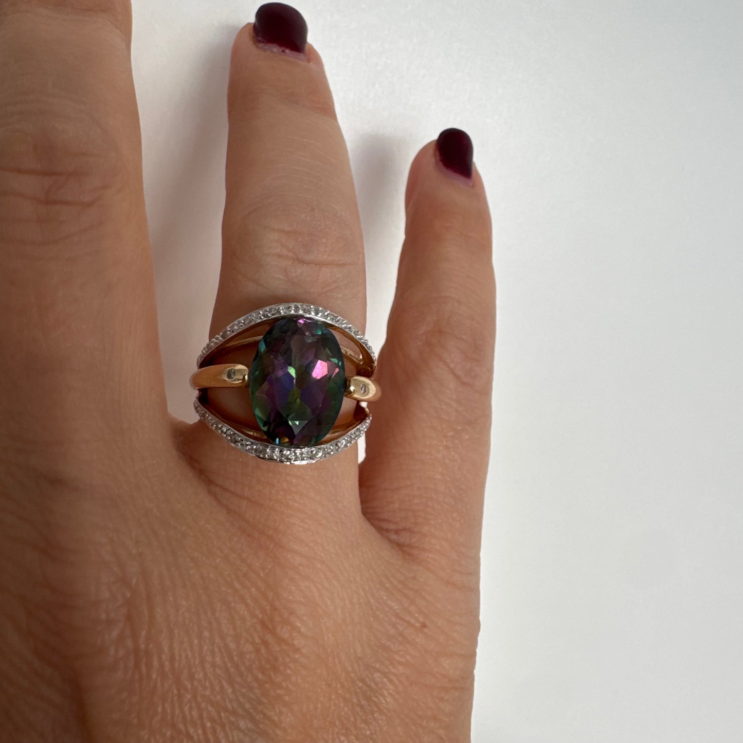 14K gold ring set with an oval Mystic Topaz