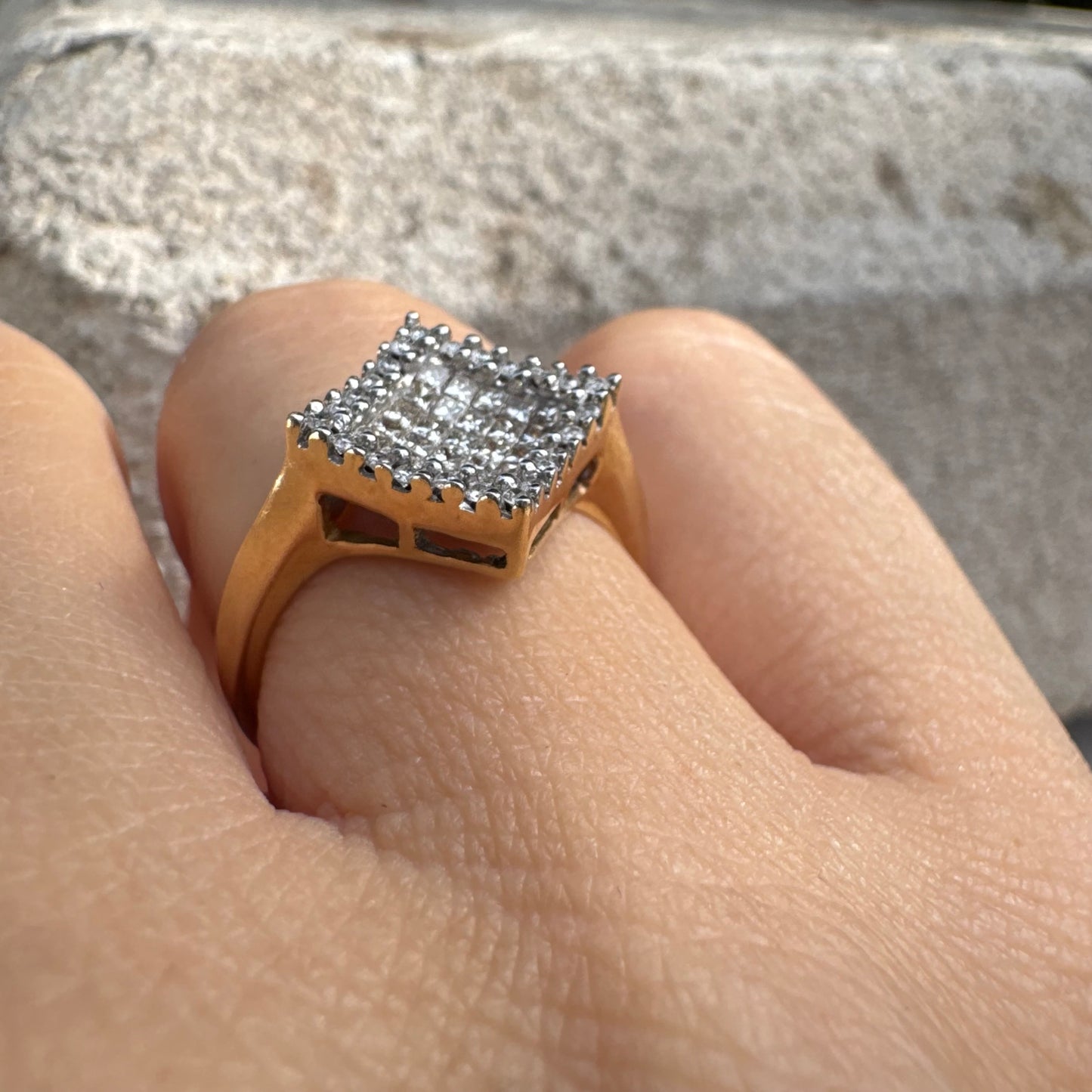 טבעת זהב 14 קראט בעיצוב ריבועי משובצת יהלומים בחיתוך פרינסס ומוקפת מסגרת יהלומים עגולים. 