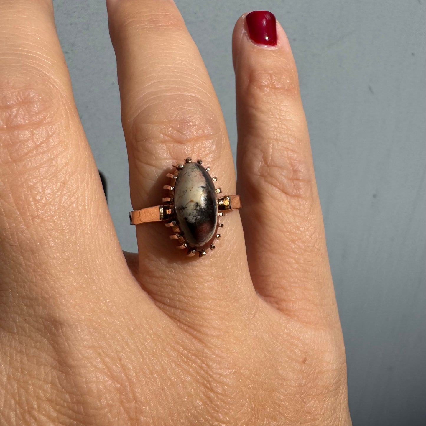 טבעת זהב 14 קראט משובצת אבן ג’ספר ייחודית בגווני קרם, שחור ואדום. 