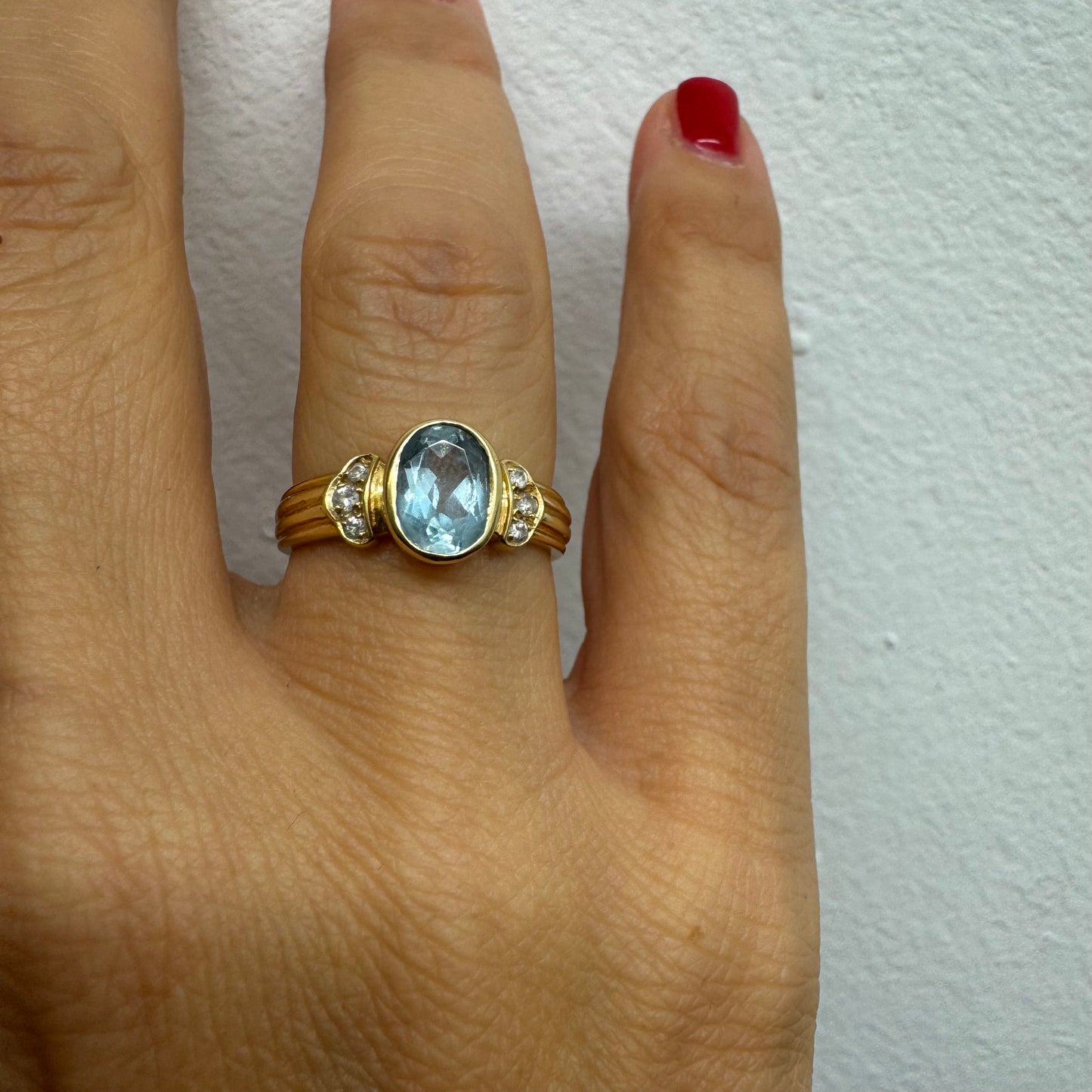 טבעת זהב 18 קראט משובצת אבן אקוומרין בגוון תכלת רך, עם יהלומים בצדדים שמוסיפים ברק עדין. 