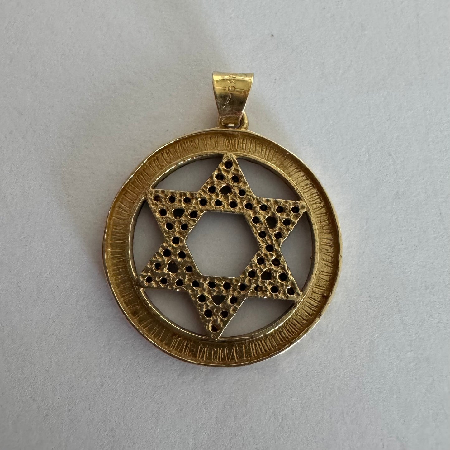 תליון מגן דוד מזהב 14 קראט, משובץ יהלומים שחורים היוצרים ניגוד מרשים מול הזהב.