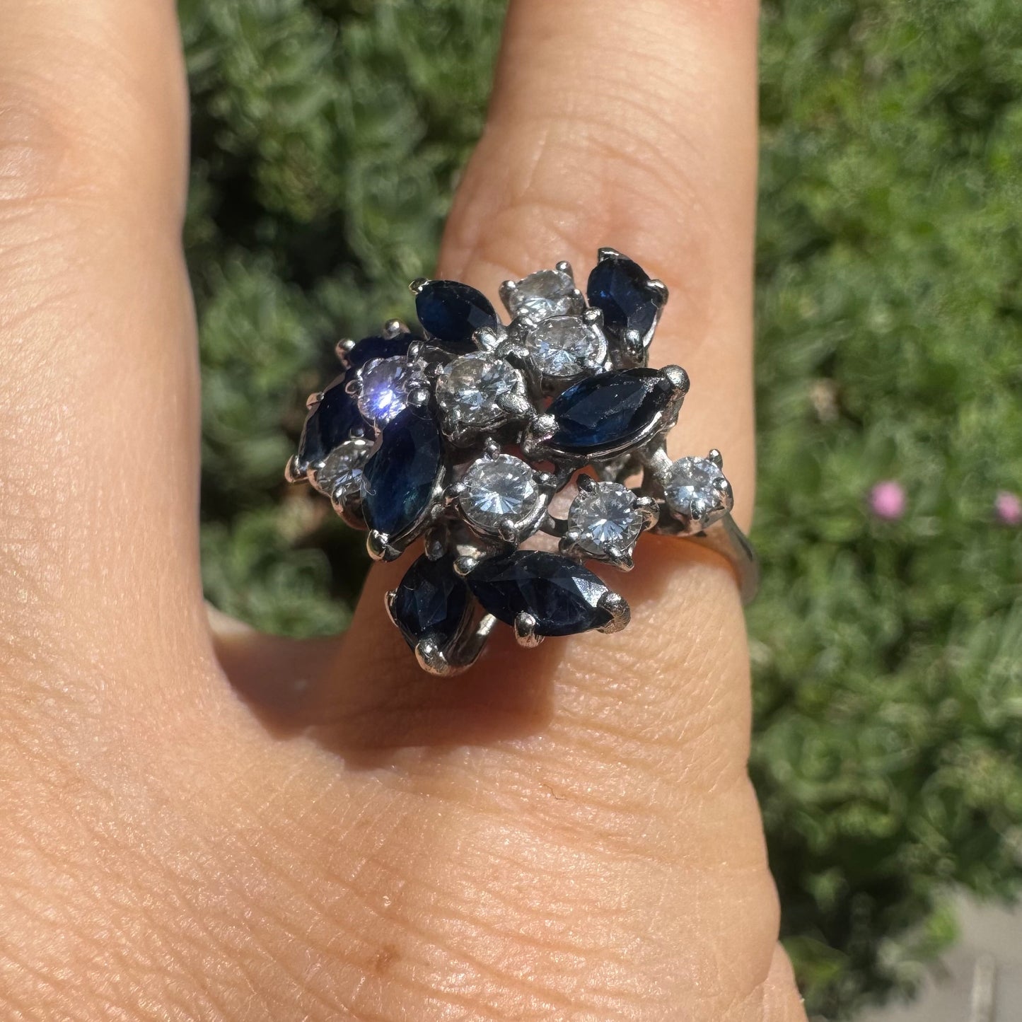 18K gold cluster ring featuring marquise-cut blue sapphires and round brilliant Diamonds arranged in a floral design.