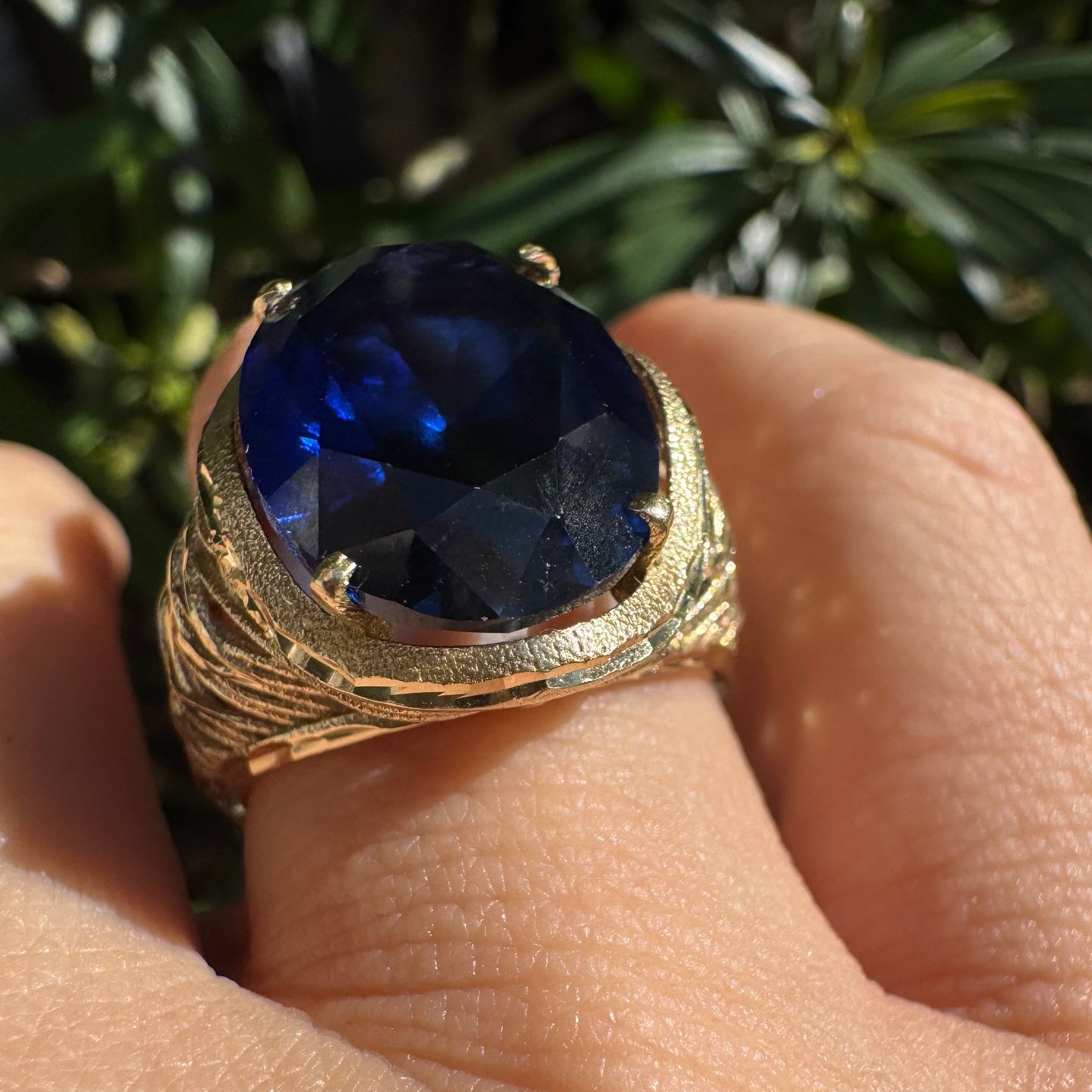 14K gold ring set with a deep navy-blue oval Sapphire in a dramatic openwork setting