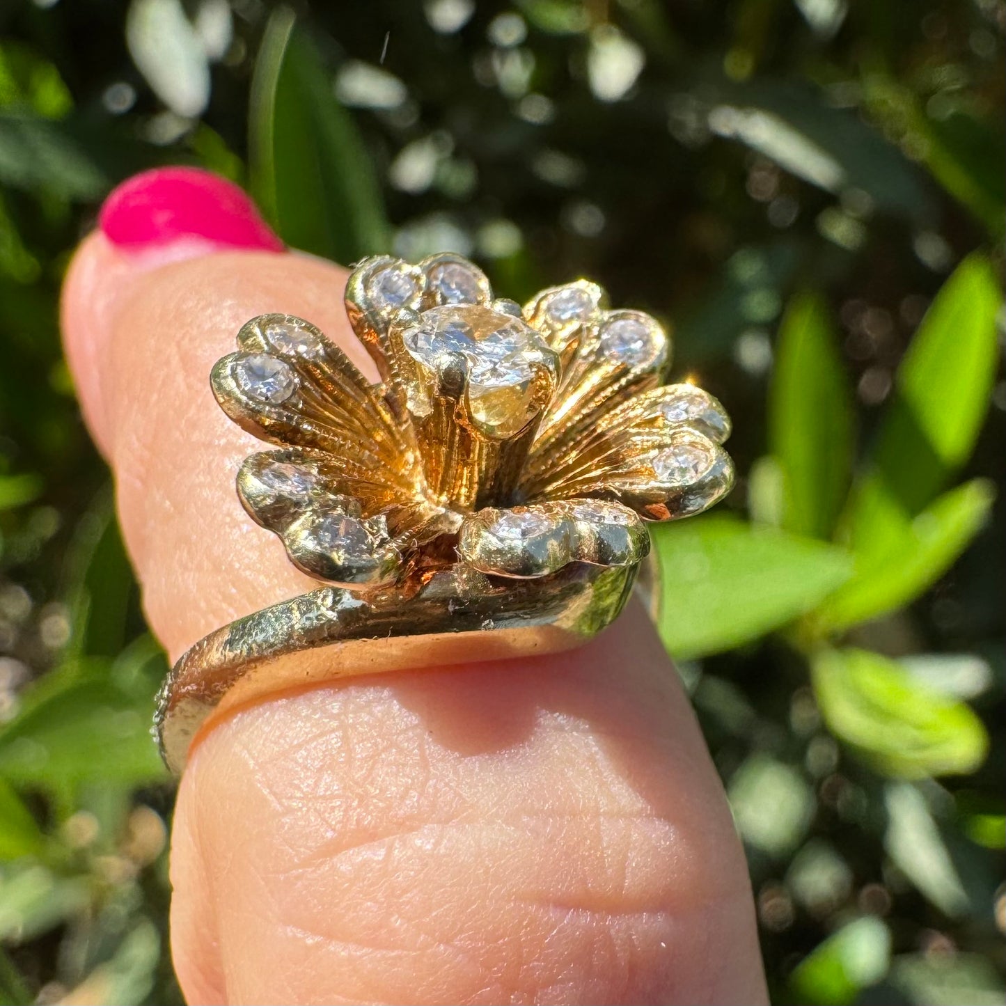 14K gold ring in a floral design, set with sparkling Diamonds at the center and around the petals.