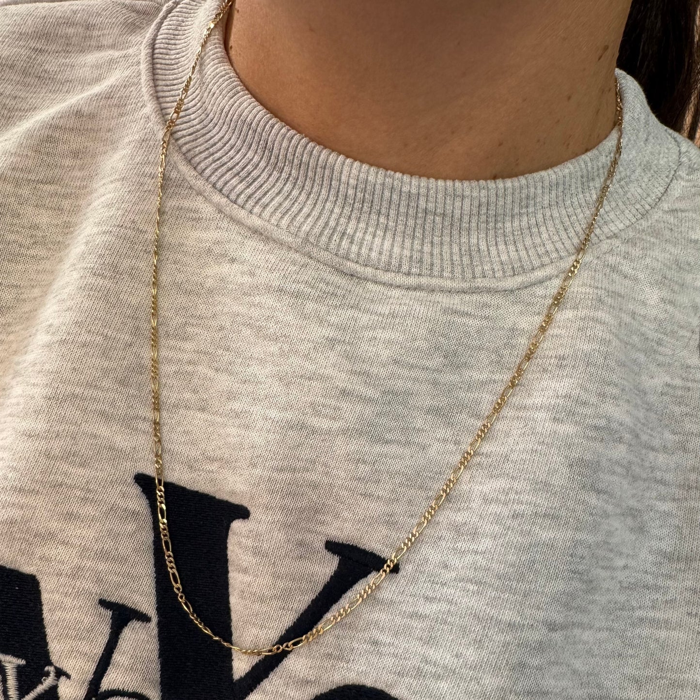 שרשרת זהב צהוב 14 קראט בעיצוב חוליות דקות ומוארכות עם טוויסט עדין שנותן לה מראה אלגנטי ונקי.