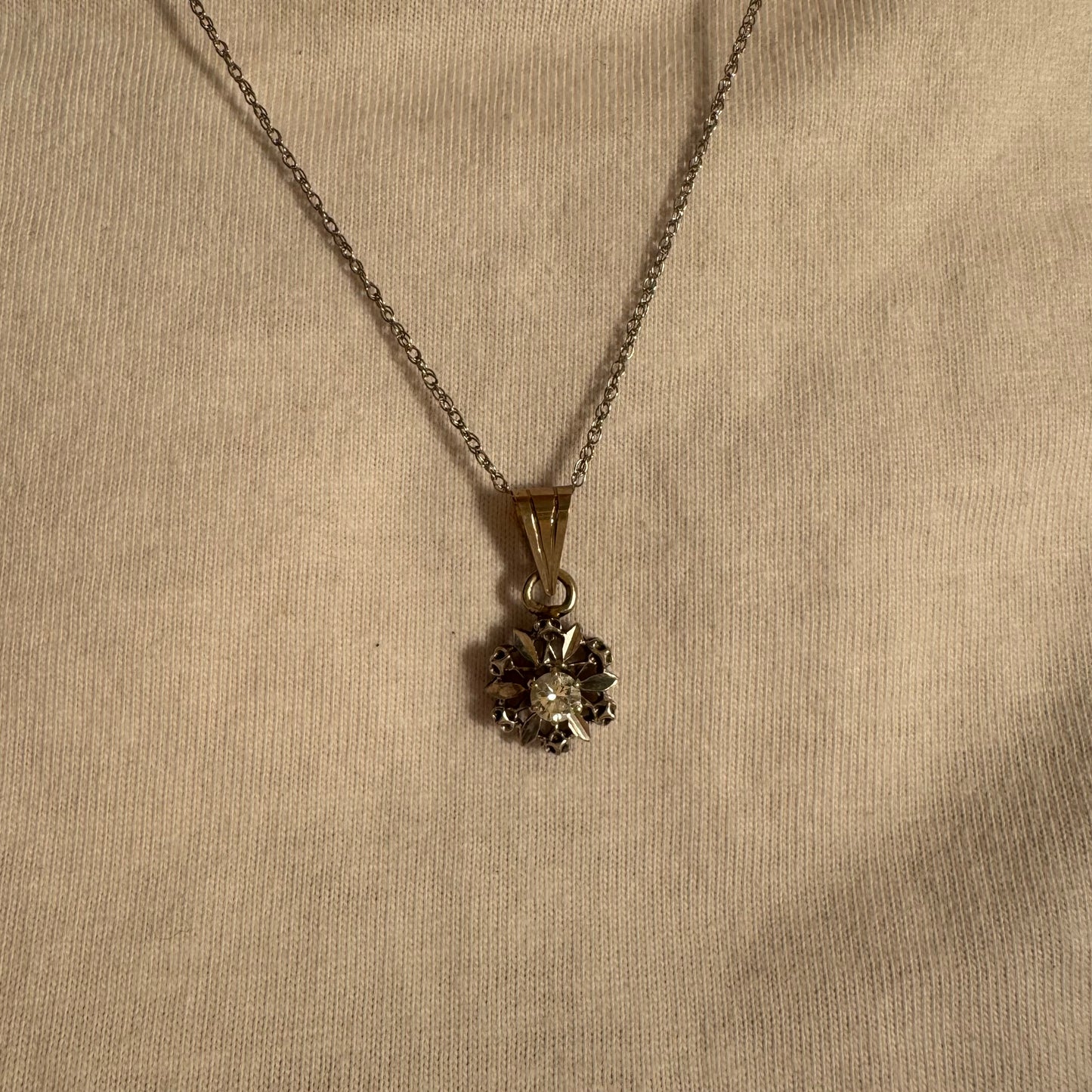 תליון זהב 14 קראט משובץ יהלום מרכזי בעיצוב פרח עדין ומלא נוכחות.