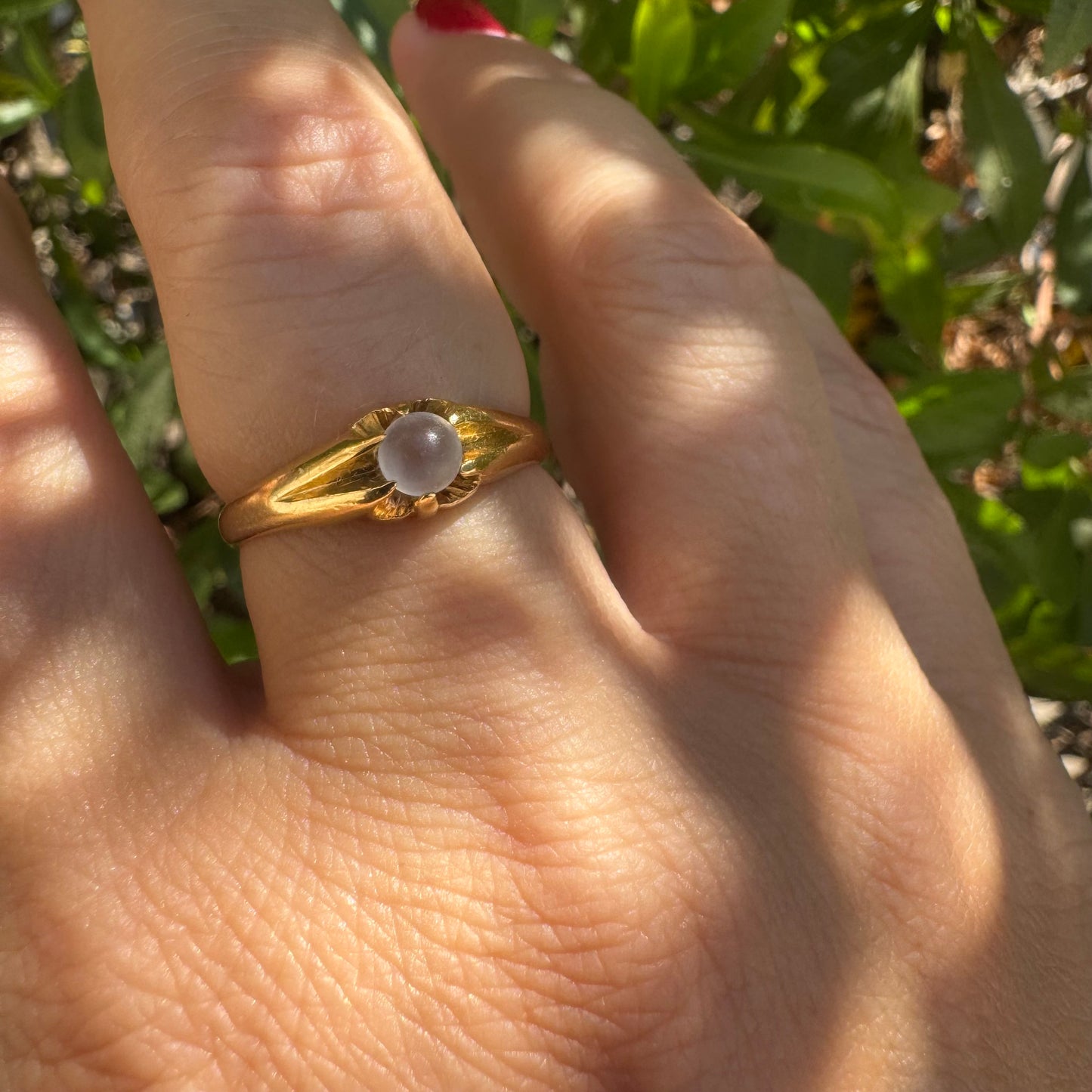 18K yellow gold ring featuring a smooth round Moonstone set in a delicate floral-inspired design.