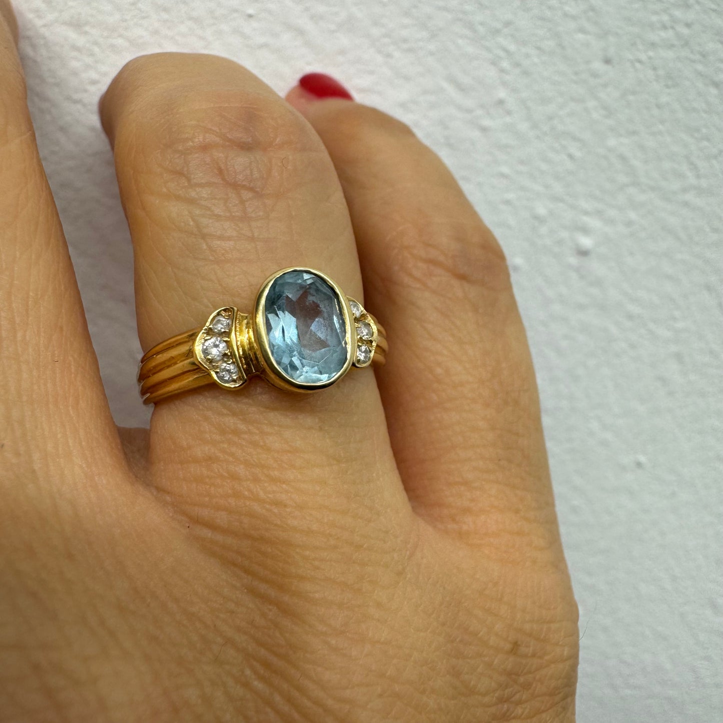 טבעת זהב 18 קראט משובצת אבן אקוומרין בגוון תכלת רך, עם יהלומים בצדדים שמוסיפים ברק עדין. 